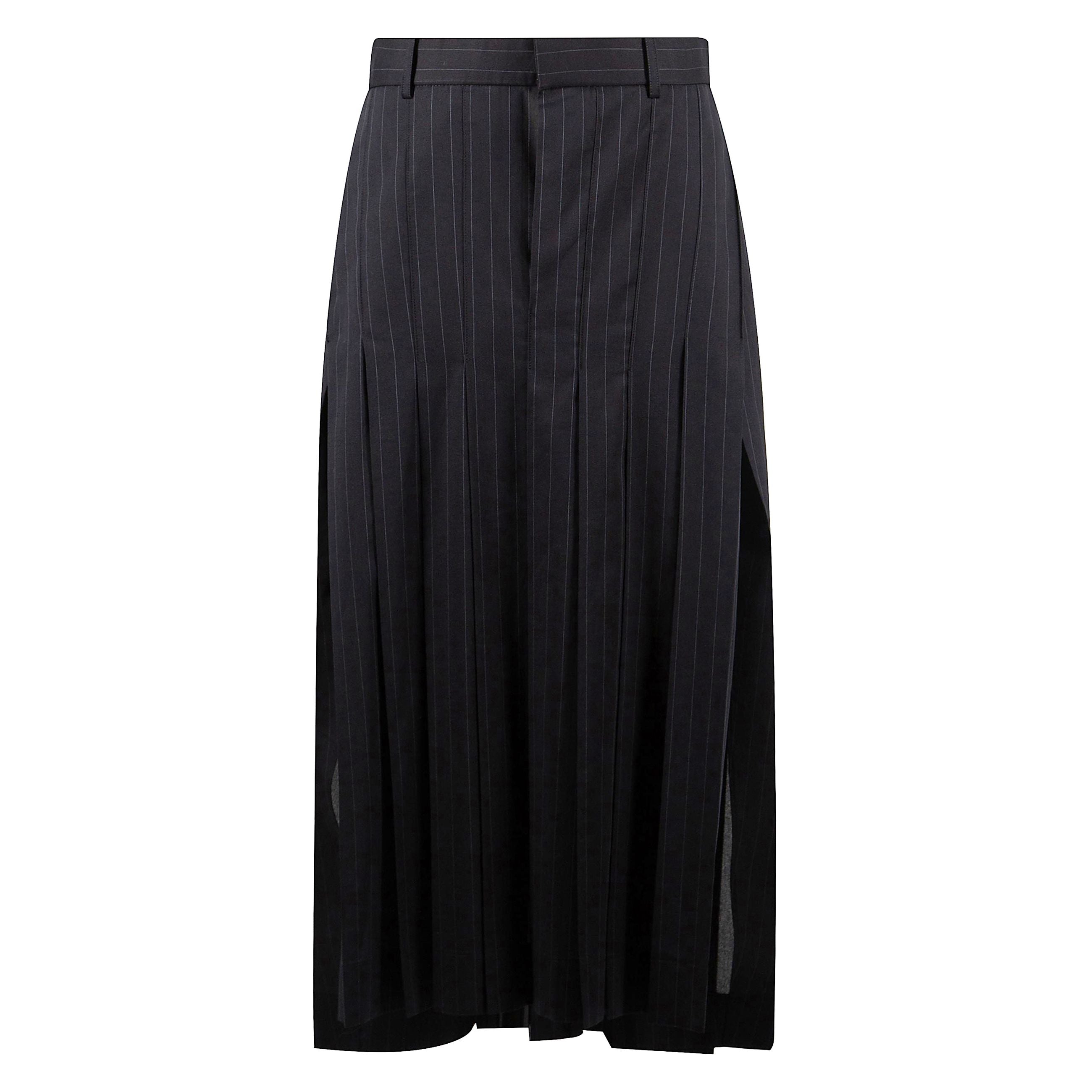 E' un capo realizzato in pura lana nera, presenta un design strutturato e asimmetrico, con una lunghezza mini. le caratteristiche includono tasche laterali, un sottogonna visibile con dettagli a contrasto, spacchi laterali e un orlo asimmetrico. la chiusu