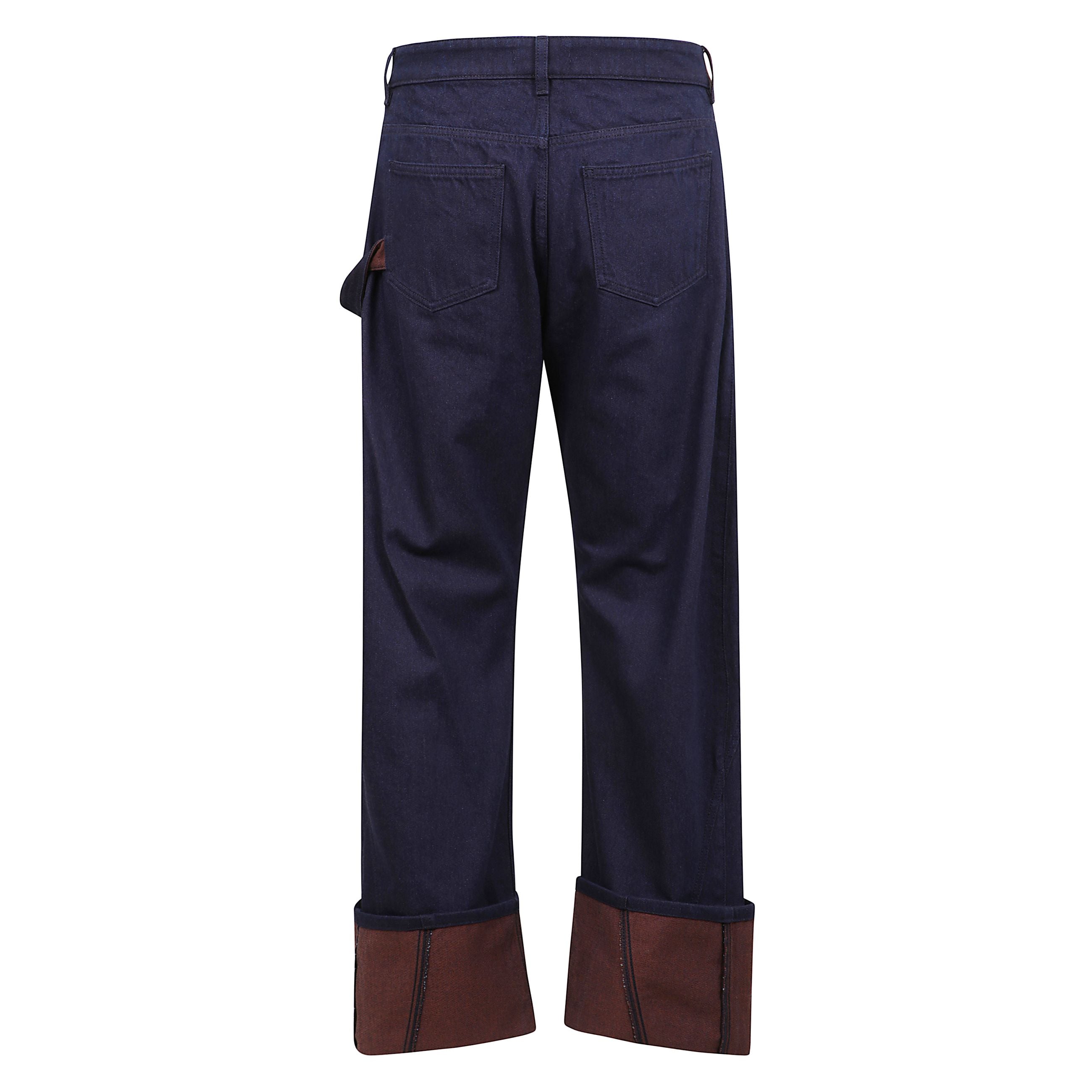 Denim con risvolto a contrasto in rosso caldo sull’orlo. silhouette asimmetrica con cuciture curve e vestibilità ampia ispirata all’abbigliamento da lavoro. design a cinque tasche, passanti per cintura e chiusura con bottoni e zip.