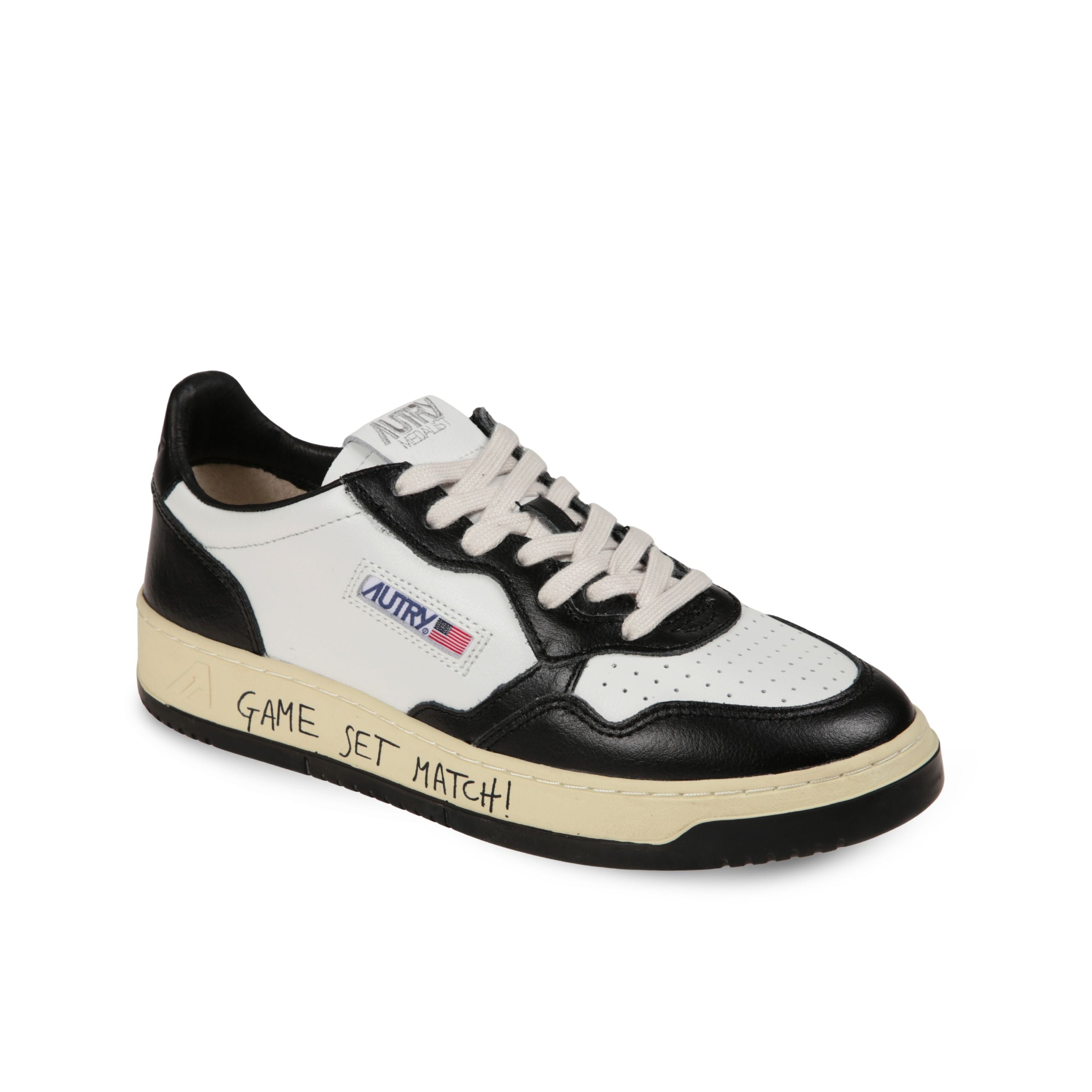Sneakers autry medalist low. design in pelle bianca con inserti in pelle nera. suola in gomma con scritta "game set match!" sul lato.