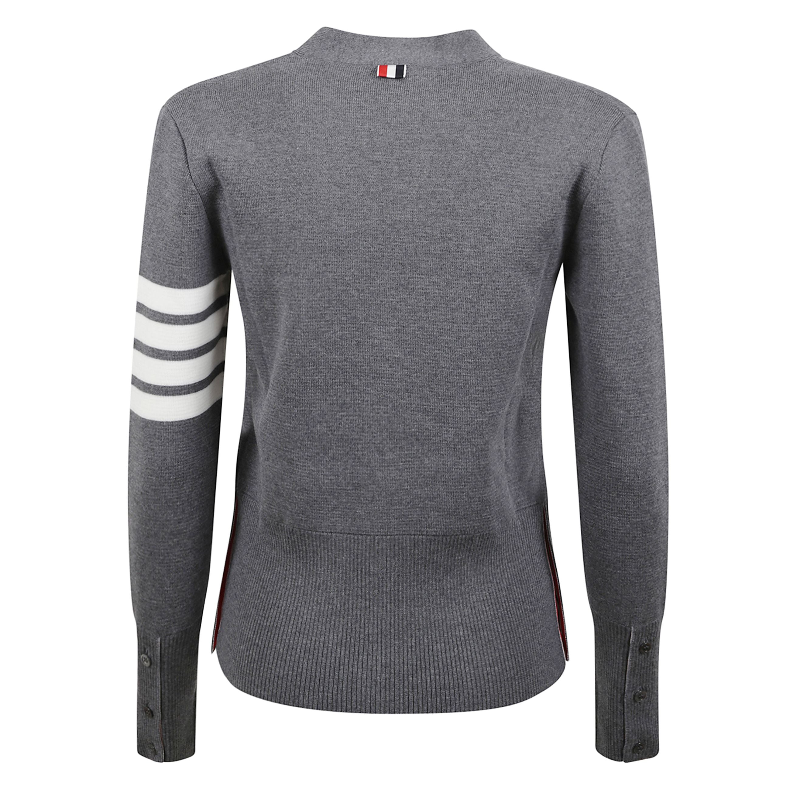 Cardigan in lana con scollo a v. dettaglio a quattro barre sulla manica. tasche a fessura. spacchi laterali con bottoni e polsini elasticizzati a coste con chiusura a bottone. linguetta in grosgrain thom browne sul retro.