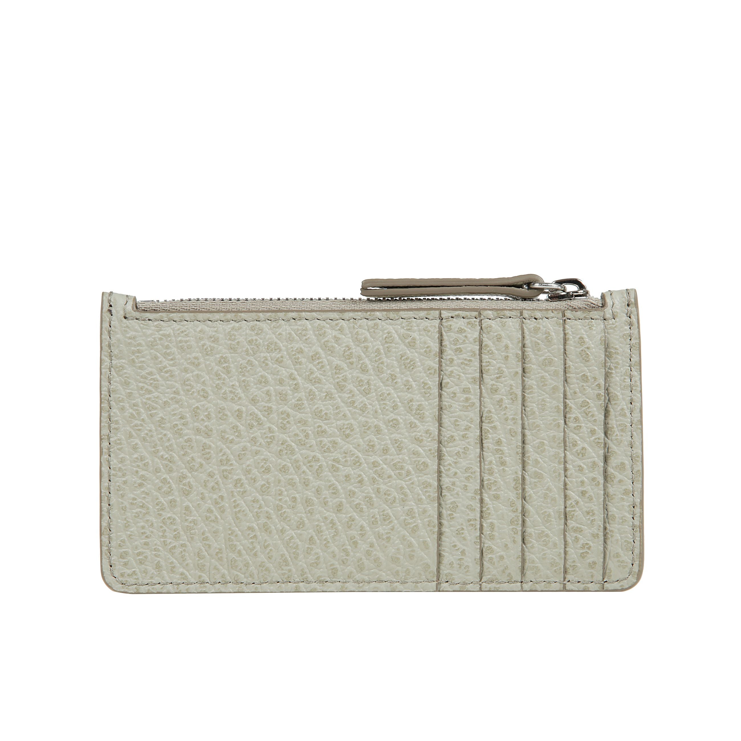 Portafoglio-portacarte in pelle martellata, con tasca a zip per le monete e cinque scomparti portatessere. numeric logo visibile allâinterno. sul retro, spiccano four stitches, caratteristica indiscussa di maison margiela : lâopposto di unâetichetta