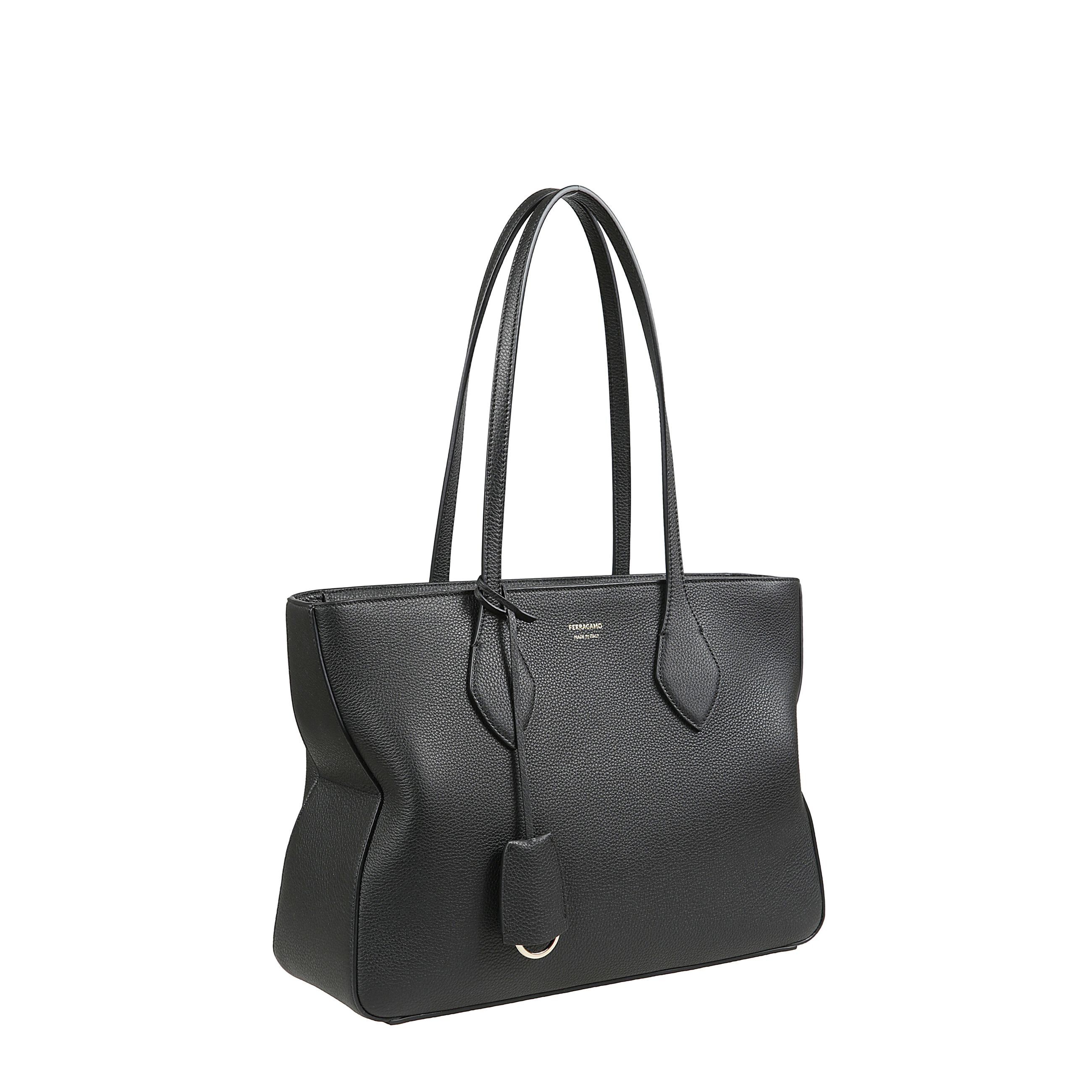 Tote bag (m) in pelle a grana con due manici ricoperti in pelle ,targhetta dorata e charm portachiavi. presenta un interno foderato in tessuto e completato da tasca piatta.