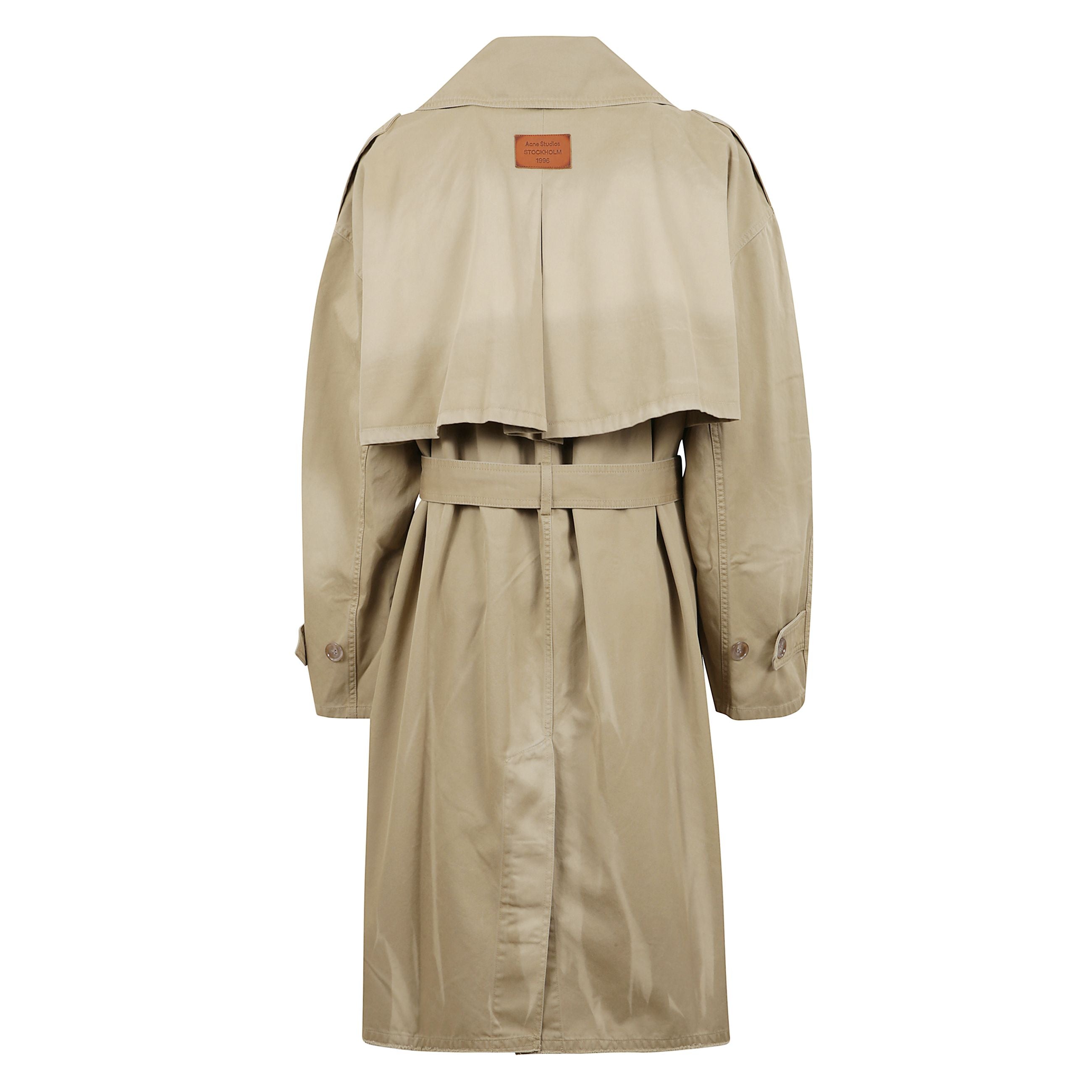 Cappotto con cintura realizzato in twill di cotone con finitura tinto in capo e logo acne studios toppa con al centro dietro. chiusura con bottoni e cintura. taglio a vestibilità regolare con spalle scese e lunghezza media.