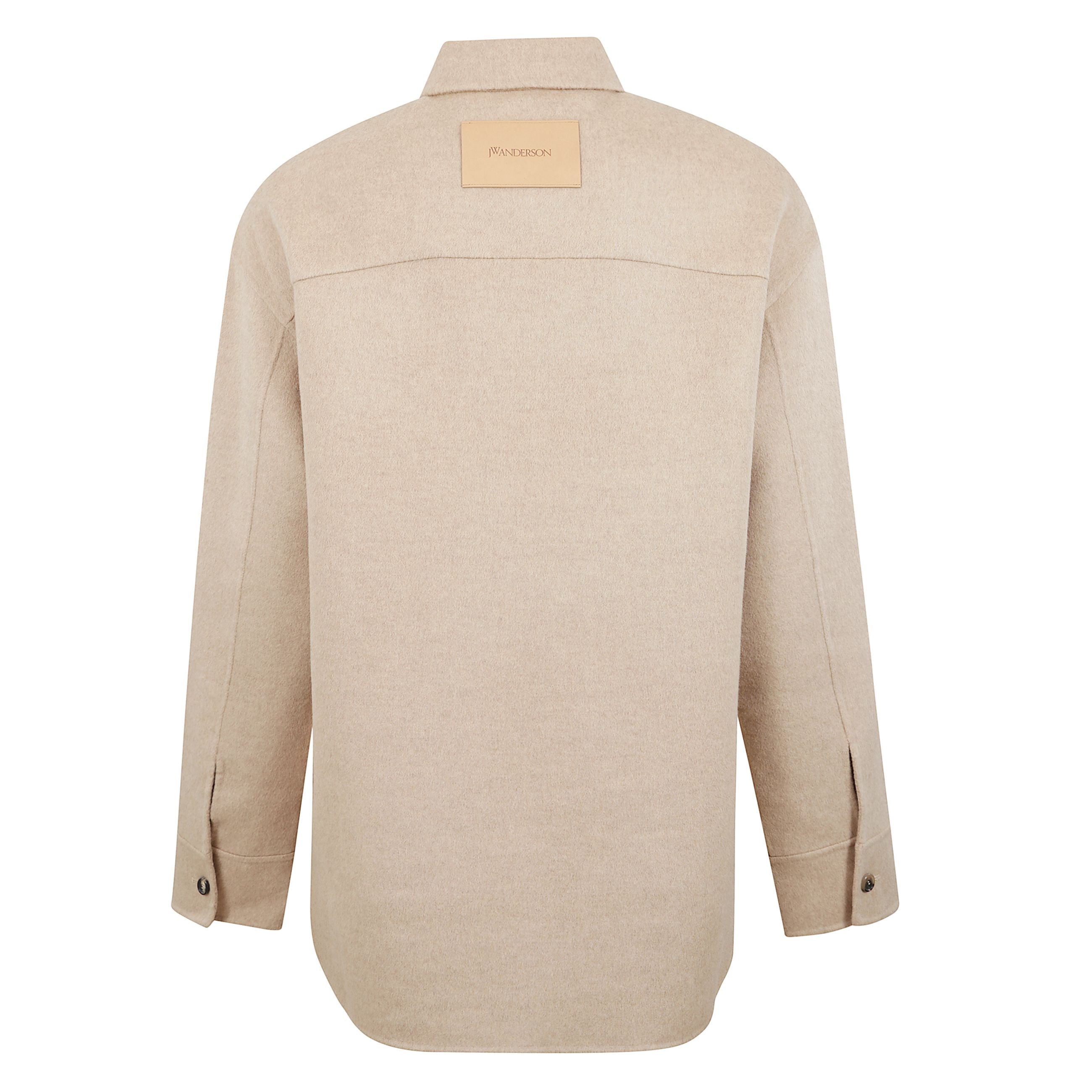 Giacca oversize con spalle scese e abbottonatura nascosta, con un bottone superiore a vista. taschino applicato sul petto e polsini con bottoni neri. toppa in pelle grezza con logo jwanderson sul retro. struttura sfoderata per un effetto fluido e senza te