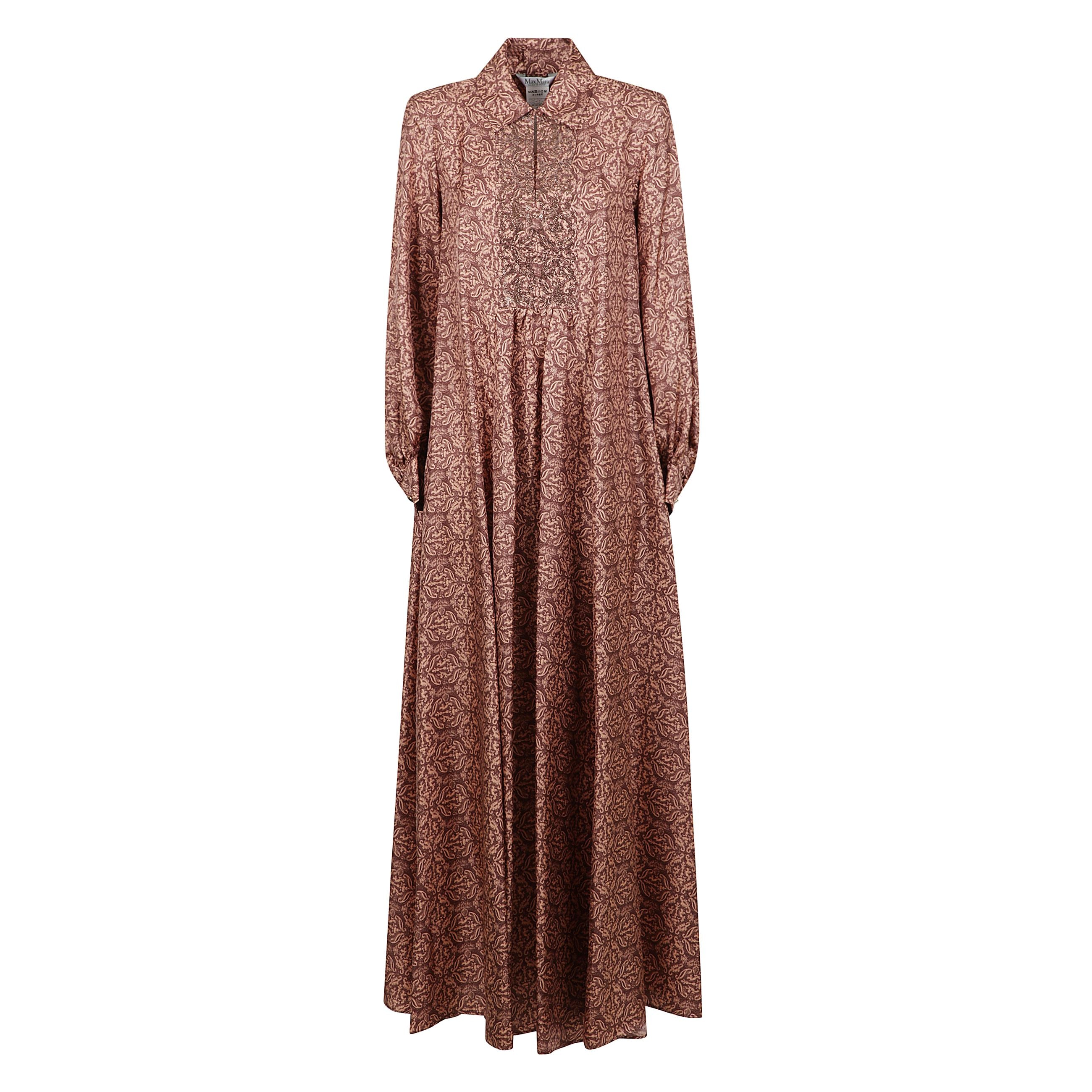 Abito chemisier lungo realizzato in prezioso twill di pura seta con motivo stampato all over e colletto modello polo con plastron ricamato con borchie e strass in tono. caratterizzato da una silhouette ampia con maniche lunghe a palloncino, polsino a cami