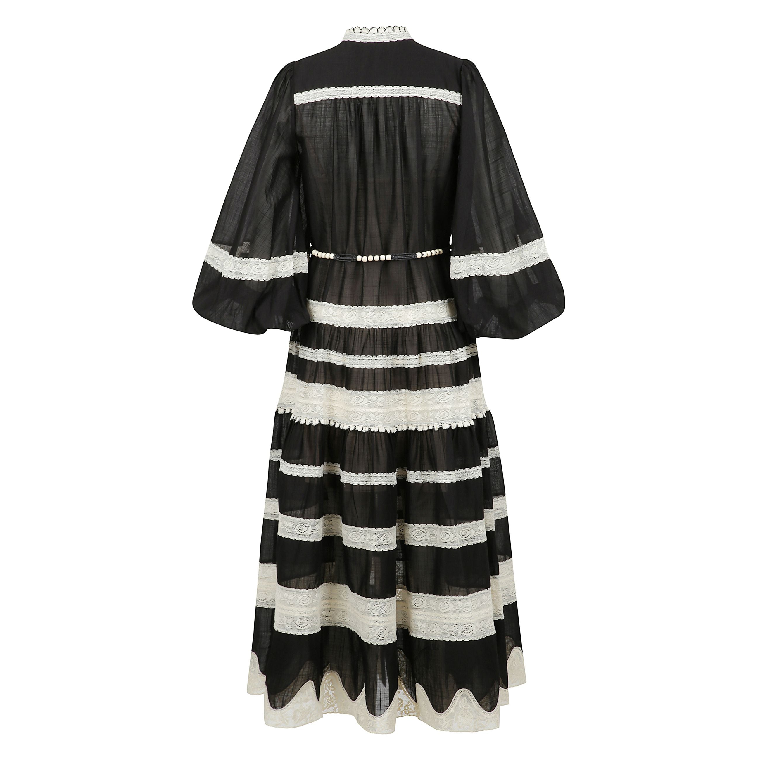 Abito in pizzo con maniche a sbuffo rhiannon in nero e crema. abito in cotone a sezioni con finiture allâuncinetto, collo alto, maniche a sbuffo con polsini elastici e bottoni al centro sul davanti.