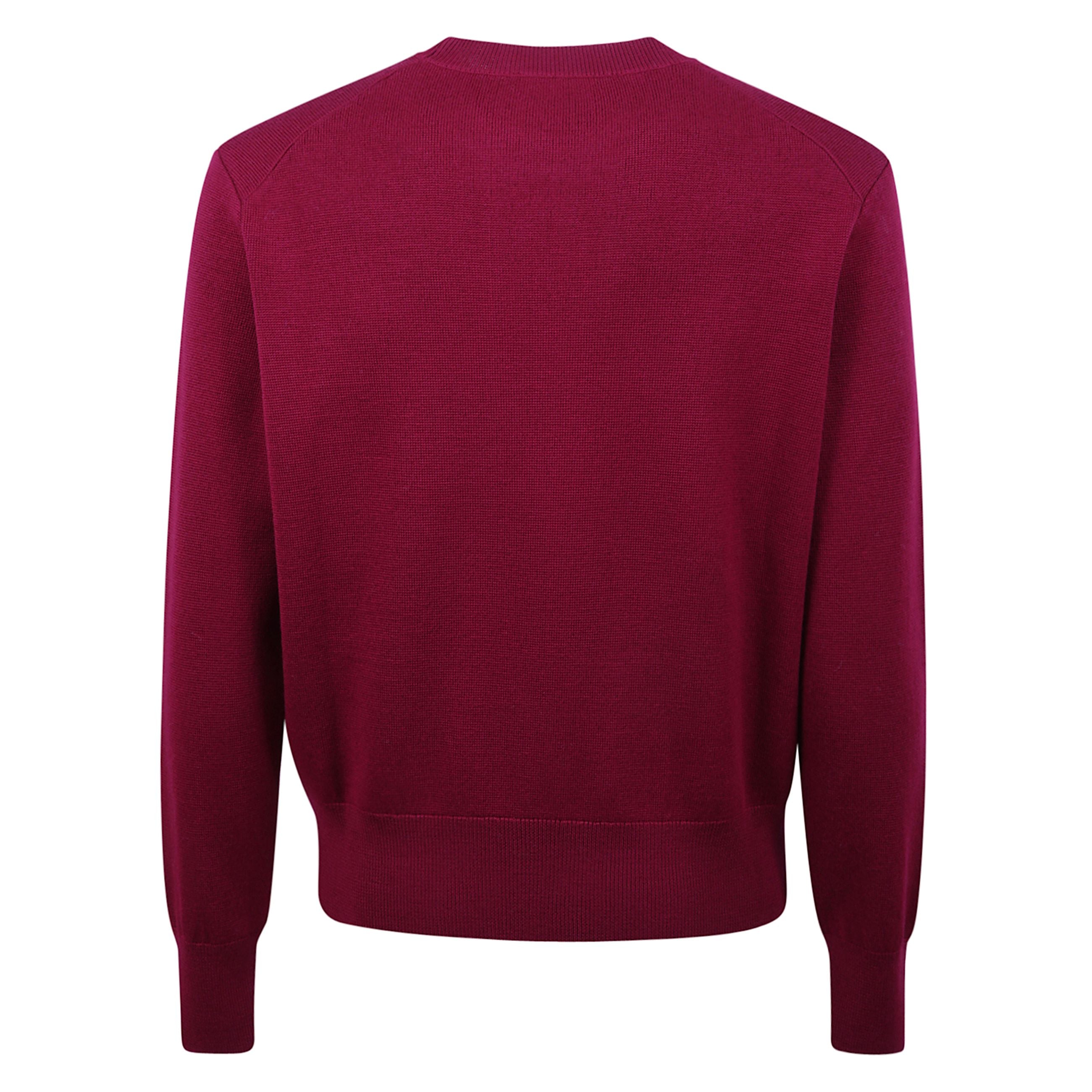 Maglione girocollo in lana, proposto in un'elegante tonalità nera. la silhouette classica è definita da bordi a costine su polsini, collo e orlo, che donano struttura al capo. il dettaglio distintivo è il ricamo del logo a contrasto sul petto, firma ic