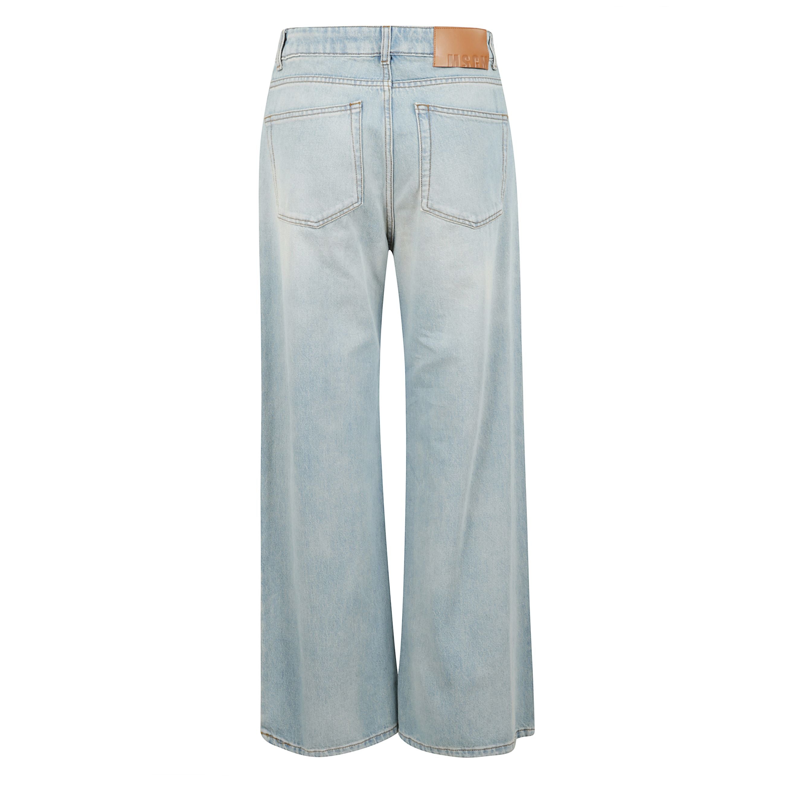 Pantalone a gamba ampia in denim di cotone lavato con cinturino coordinato in vita e logo msgm ricamato in contrasto di colore sul fianco. chiusura con zip e bottone metallico. modello cinque tasche. vestibilità oversize