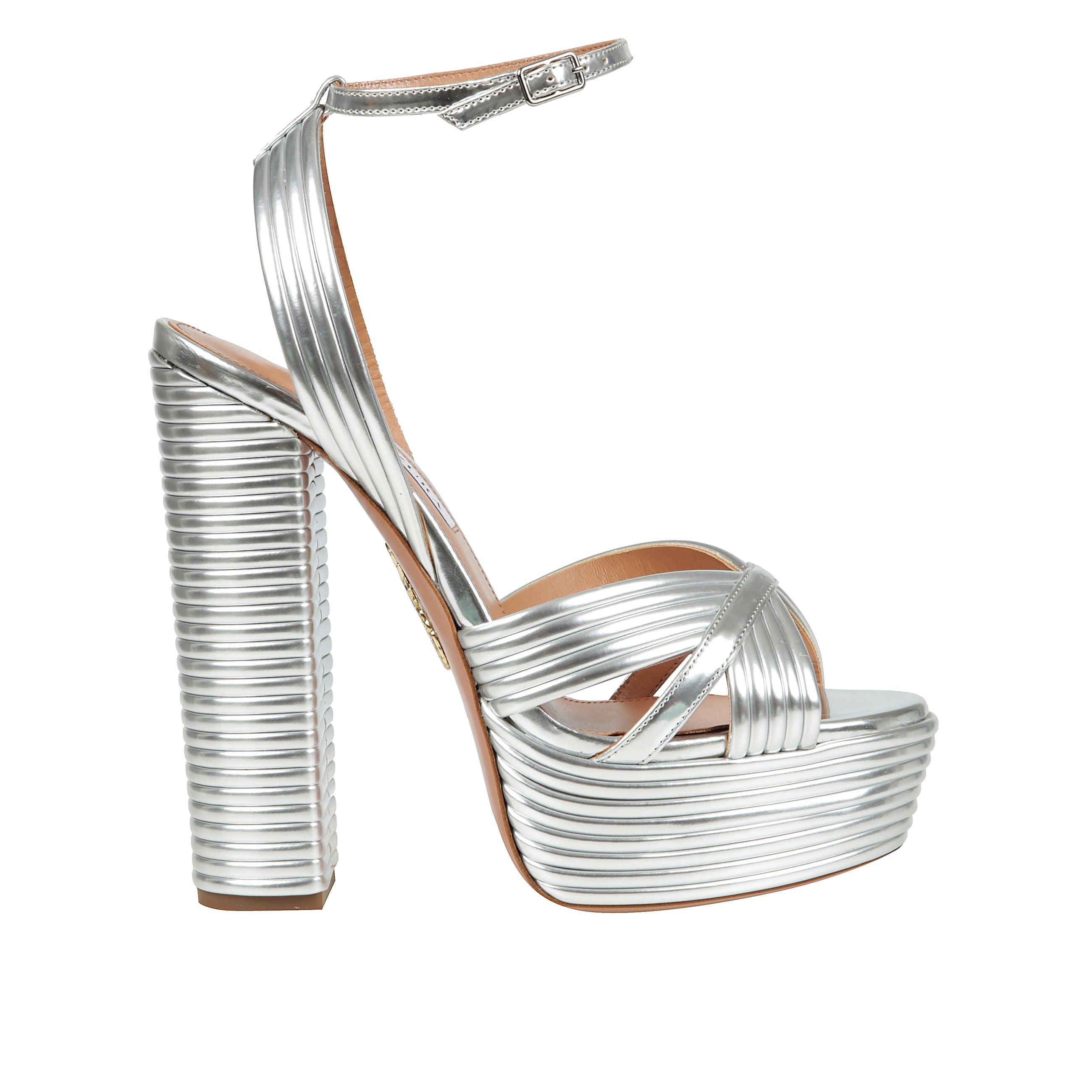 I sandali sundance plateau sono realizzati in pelle laminata e sono contraddistinti da fasce sottili che creano un sofisticato incrocio sul davanti e intorno alla caviglia. il tacco largo alto è bilanciato dal plateau.