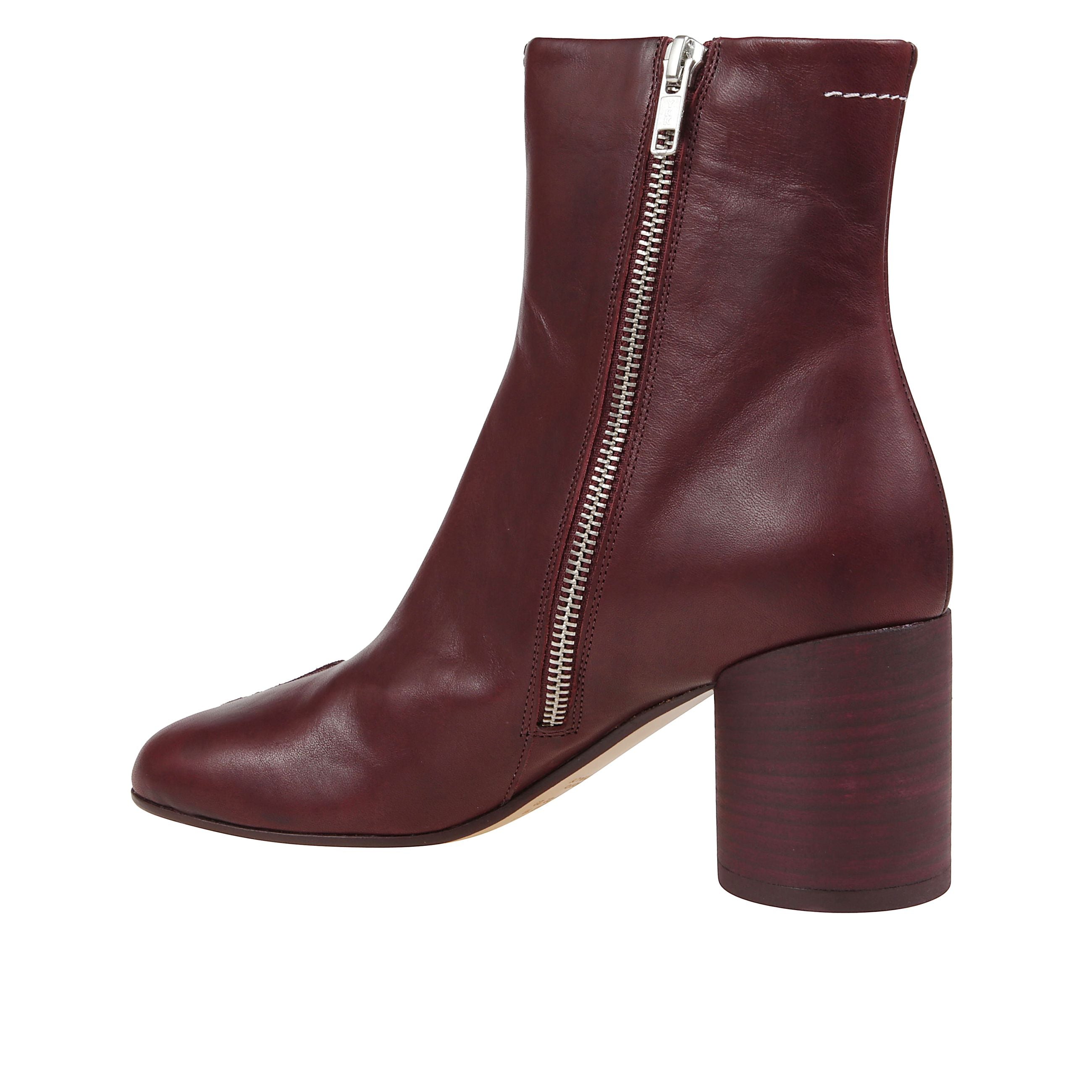 Stivaletto in pelle con punta anatomica. tacco a blocco sagomato e chiusura con zip laterale. impreziosito da lievi impunture bianche sul retro.