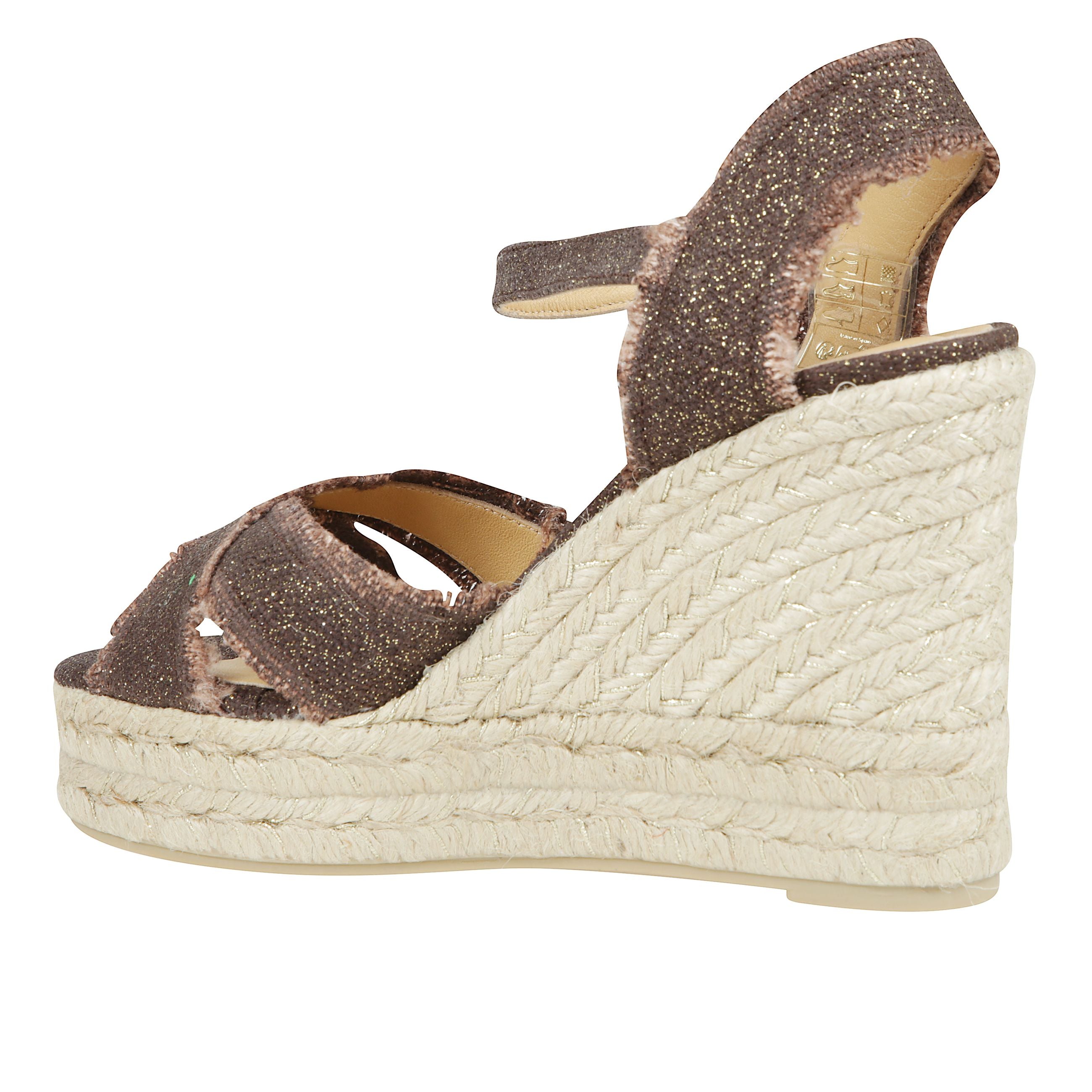 Sandalo bromelia in lino metallizzato con taglio incrociato e un vivace effetto sfrangiato. chiusura a cinturino, soletta imbottita e zeppa in juta e lurex di 11 cm con doppio plateau.