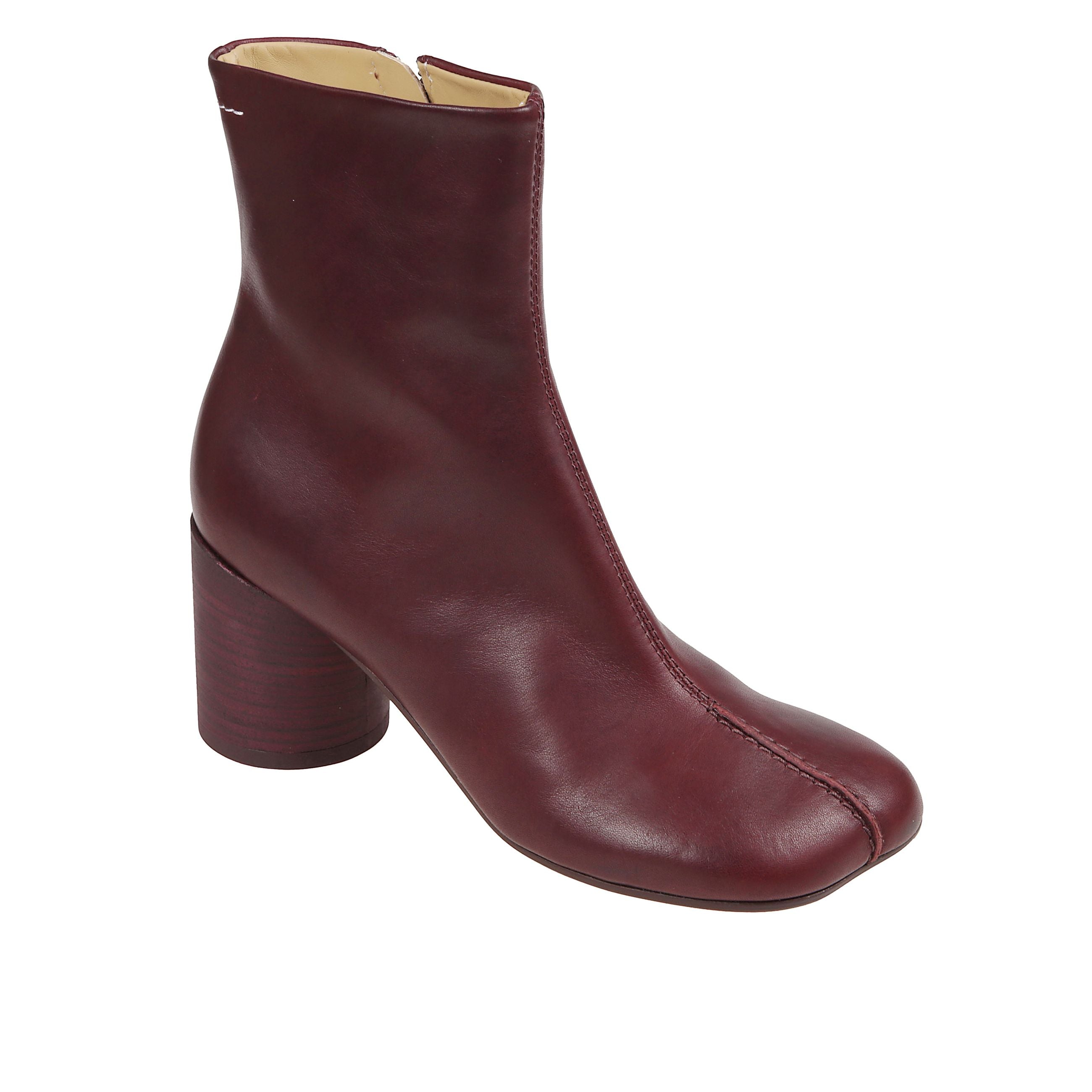 Stivaletto in pelle con punta anatomica. tacco a blocco sagomato e chiusura con zip laterale. impreziosito da lievi impunture bianche sul retro.