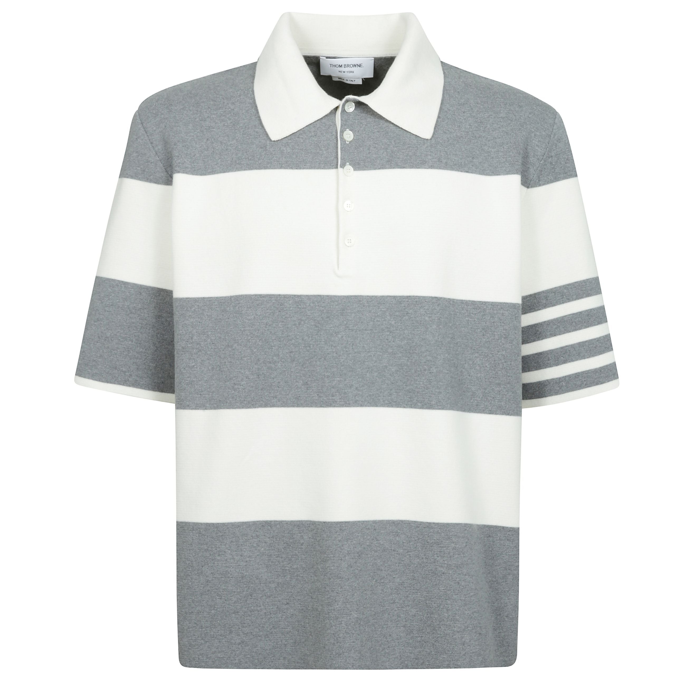 La maglia polo milano in cotone di thom browne è un capo dallo stile elegante e distintivo. presenta un colletto classico e una chiusura frontale con bottoncini, mentre gli spacchi laterali aggiungono un tocco di dinamismo al design. la fantasia a righe