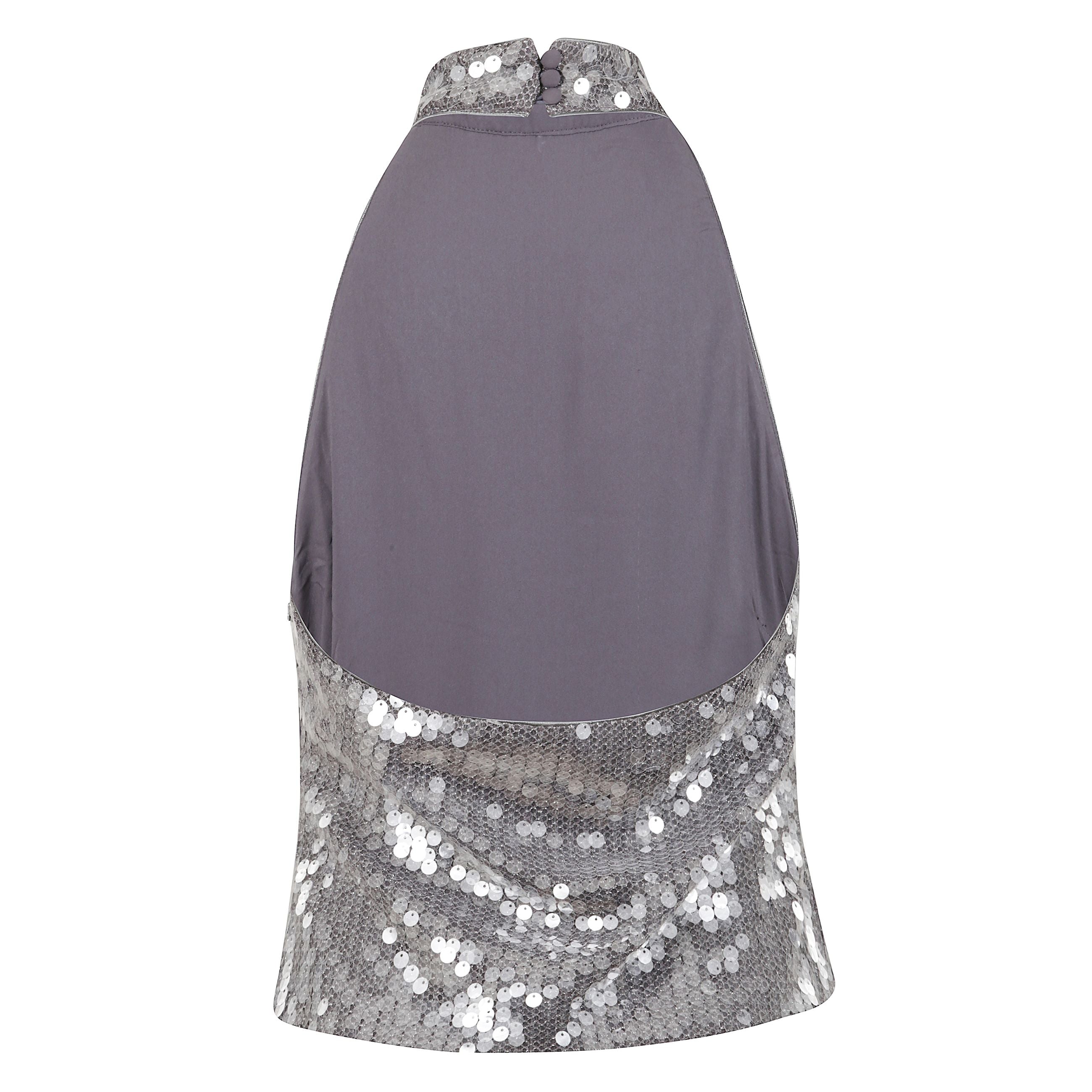 Top in rete con paillettes, modello halterneck con collo alto. scollo all'americana e design senza maniche. chiusura laterale con zip e bottoni posteriori.