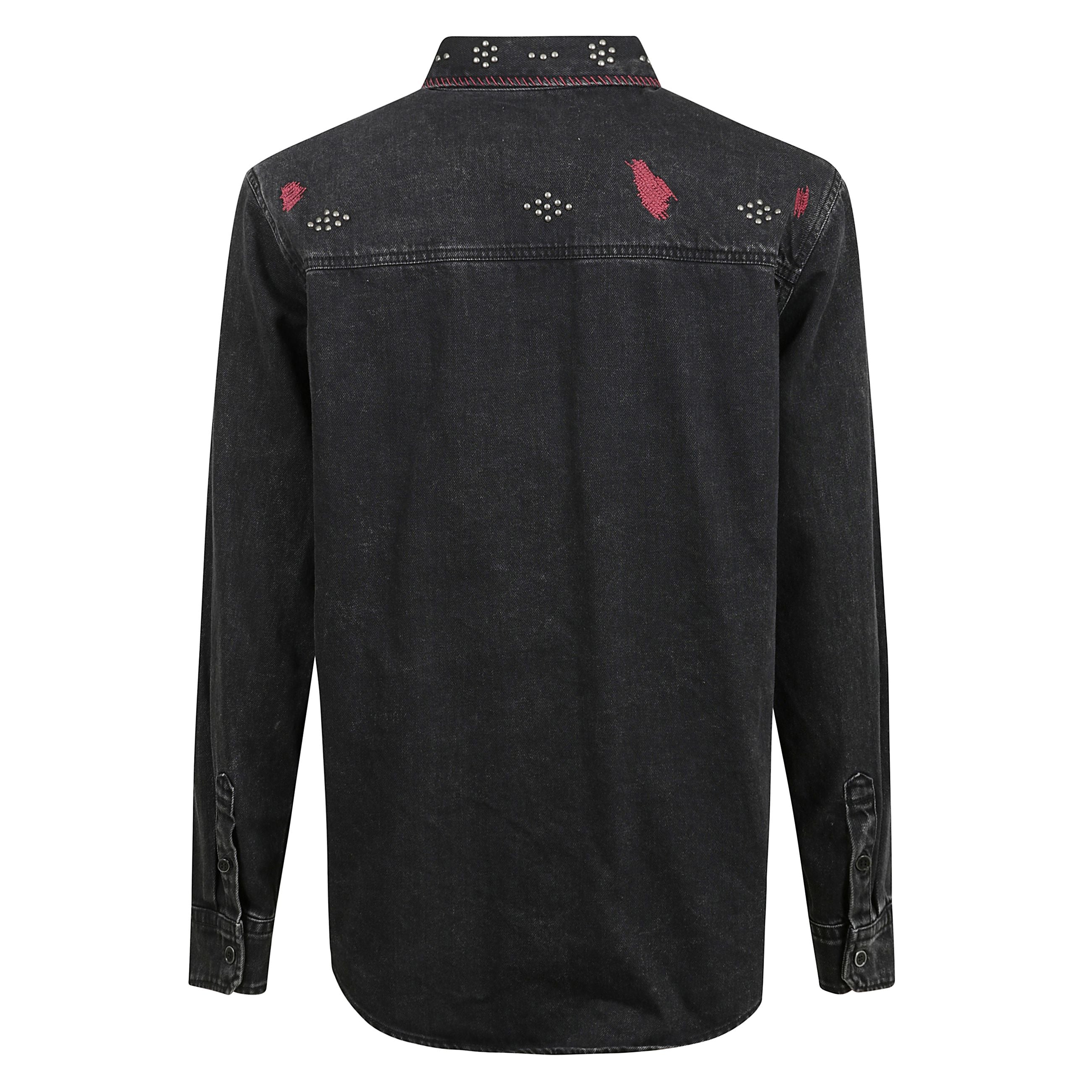 Camicia osco con chiusura frontale con bottoni,
due tasche con patta sul petto, decorazione con borchie
e motivo con ricamo