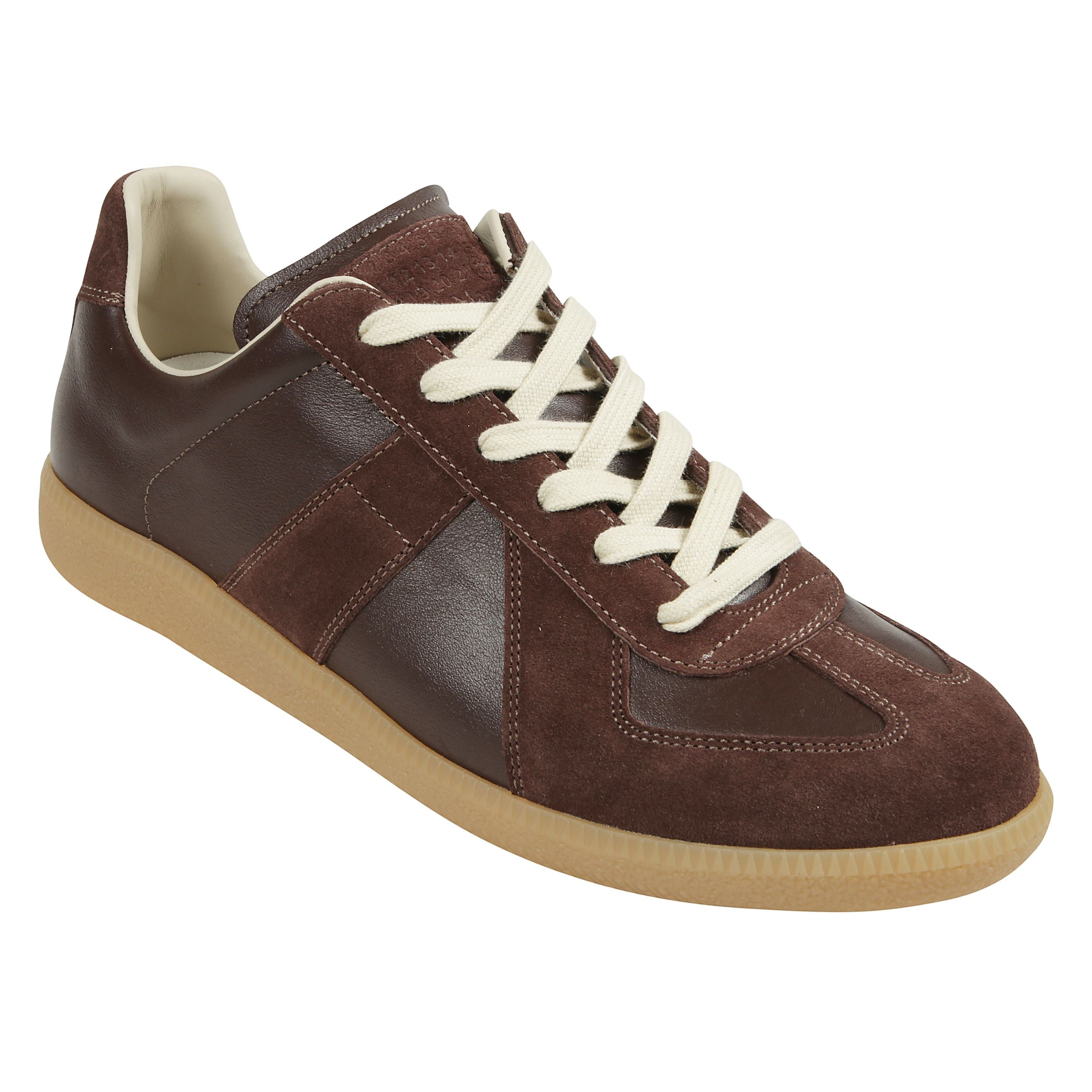 Sneakers in pelle con inserti in suede. punta tonda. lacci in cotone. suola piatta in gomma. logo numerico maison margiela cucito sulla linguetta.