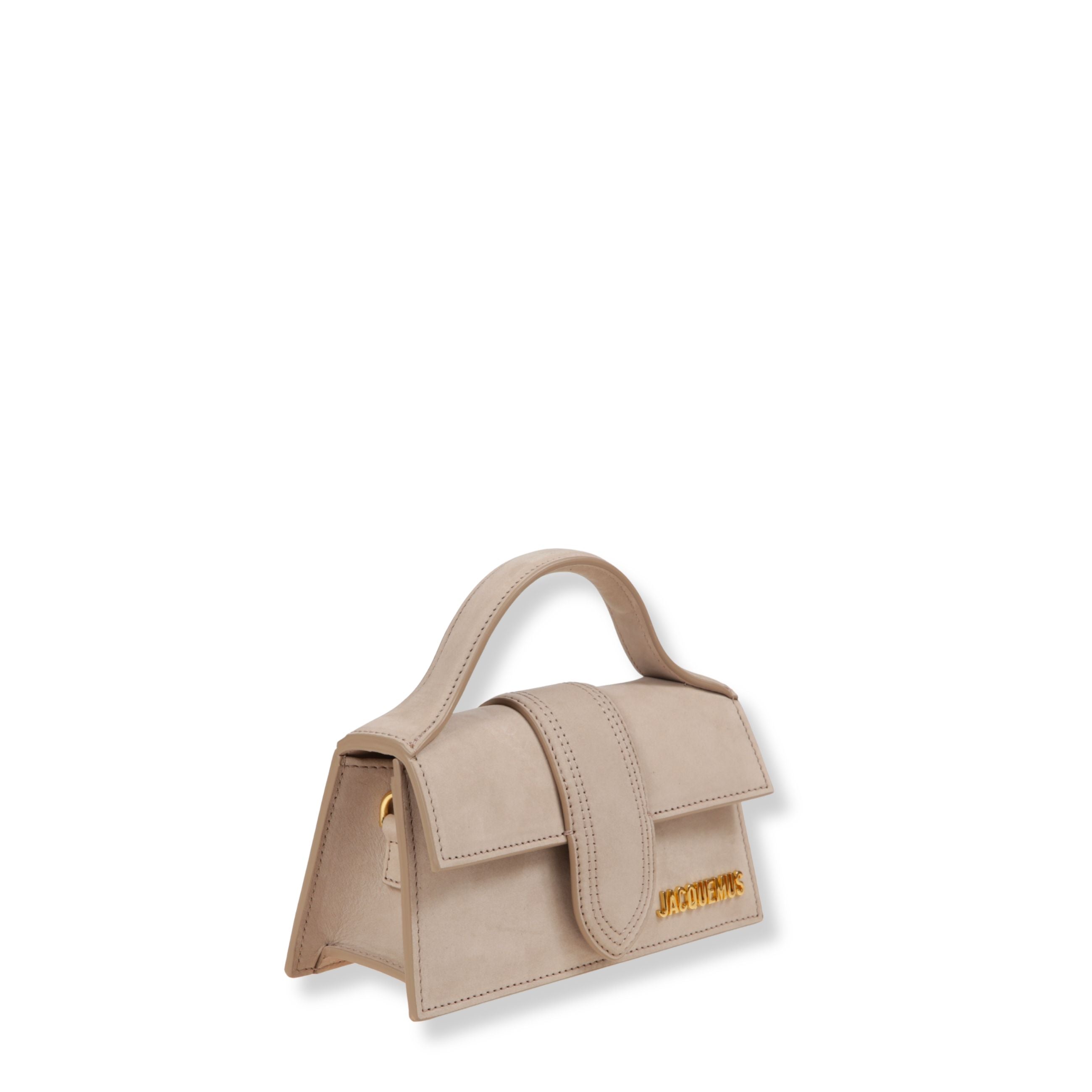 Le bambino jacquemus. struttura rigida in pelle liscia. chiusura frontale con patta e fibbia. manico arcuato. dotata di tracolla regolabile removibile.