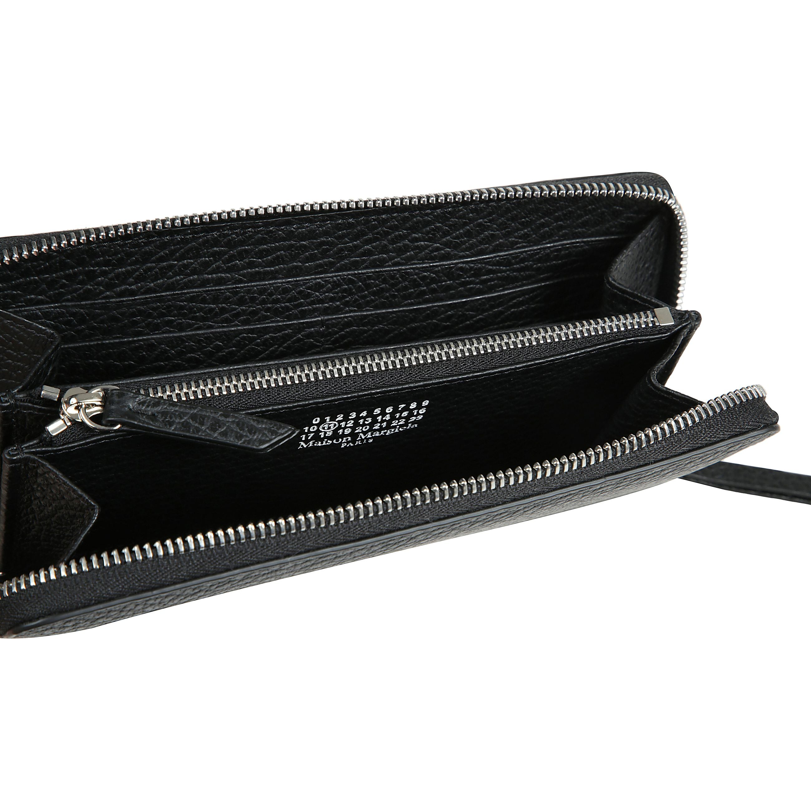 Realizzato in pelle sgranata goffrata, il portafoglio con cerniera ha un portamonete interno con zip e porta carte, con logo numerico interno. la firma di maison margiela, i quattro punti, appaiono sul retro l'opposto di un'etichetta.