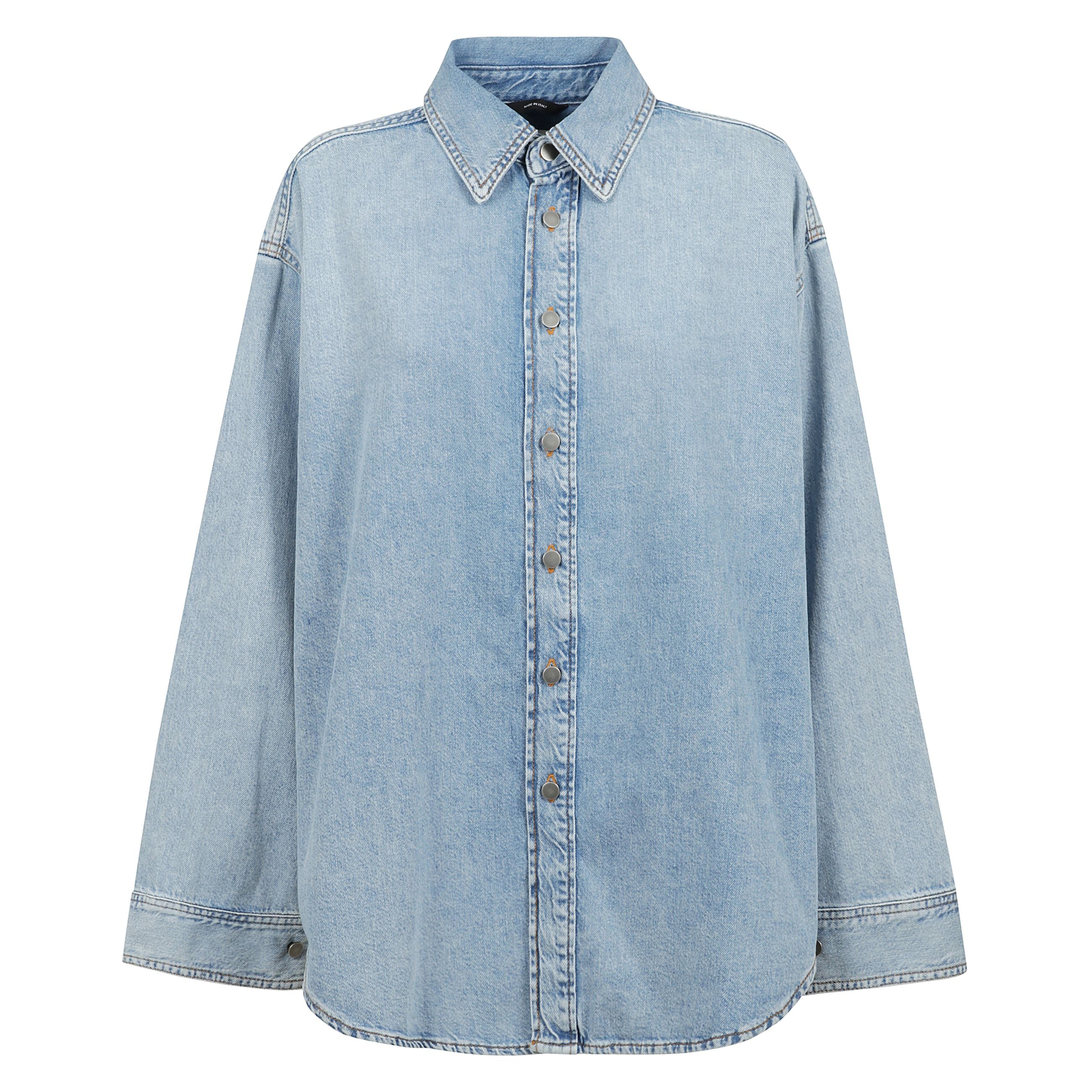 Camicia oversize ofelia realizzata in denim di cotone color azzurro. caratterizzata da colletto classico, chiusura frontale con bottoni metallici, maniche lunghe con polsini abbottonati e fondo arrotondato.