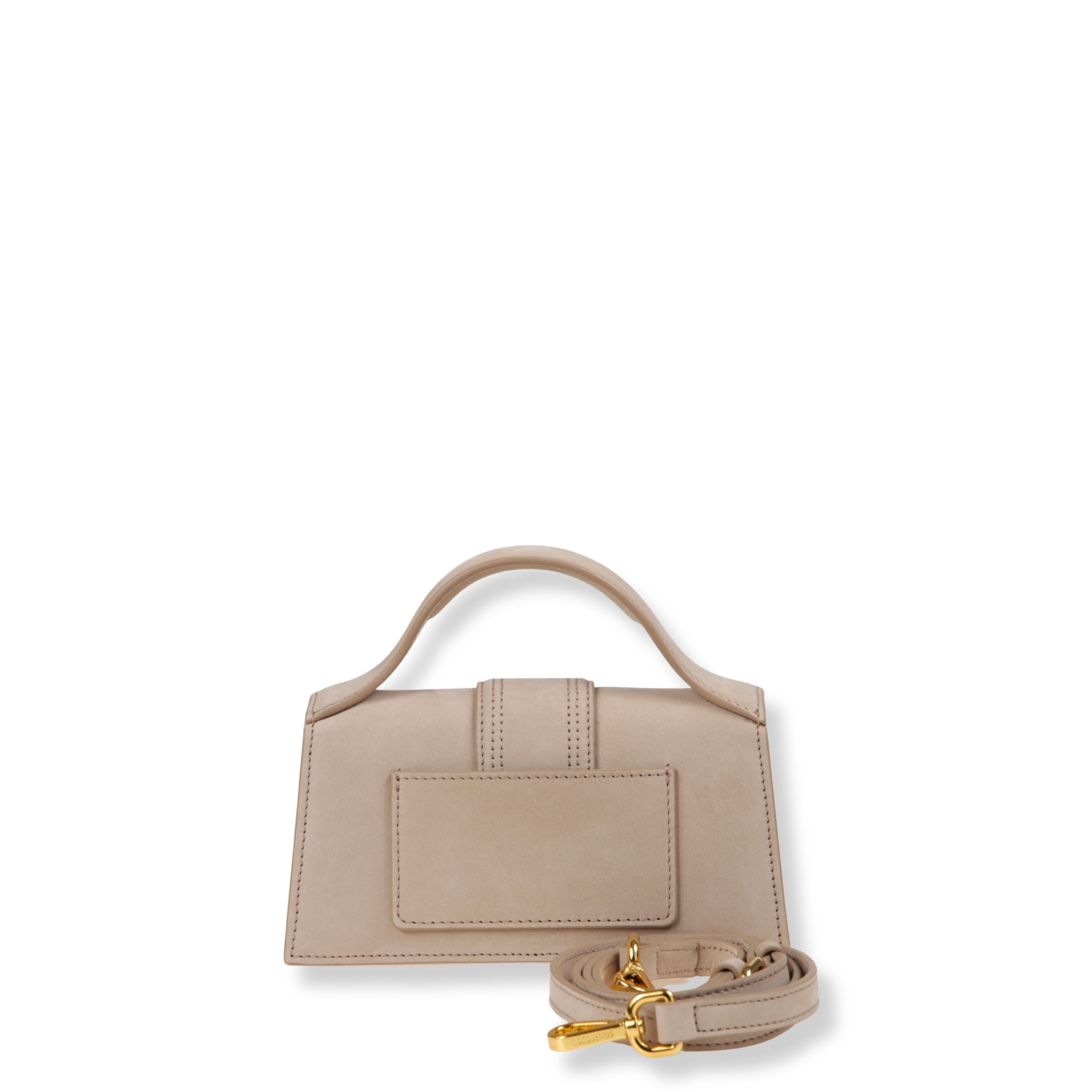 Le bambino jacquemus. struttura rigida in pelle liscia. chiusura frontale con patta e fibbia. manico arcuato. dotata di tracolla regolabile removibile.