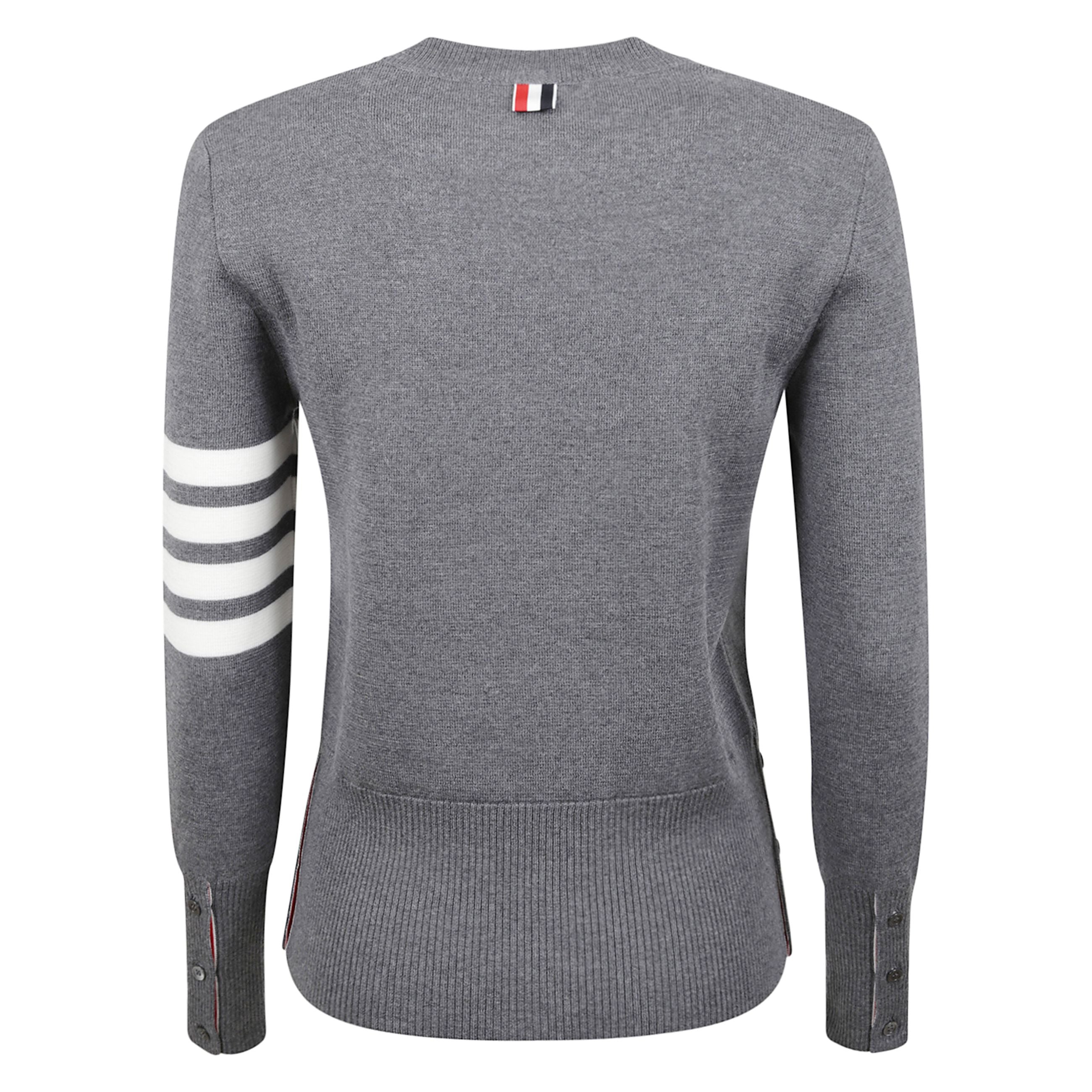 Maglia in lana a maniche lunghe con scollo a giro. spacchi laterali e sui polsi con bottoni e profili in grosgrain a righe. polsini e orlo a coste. dettaglio a quattro barre sulla manica. passante in grosgrain a righe thom browne sul retro.