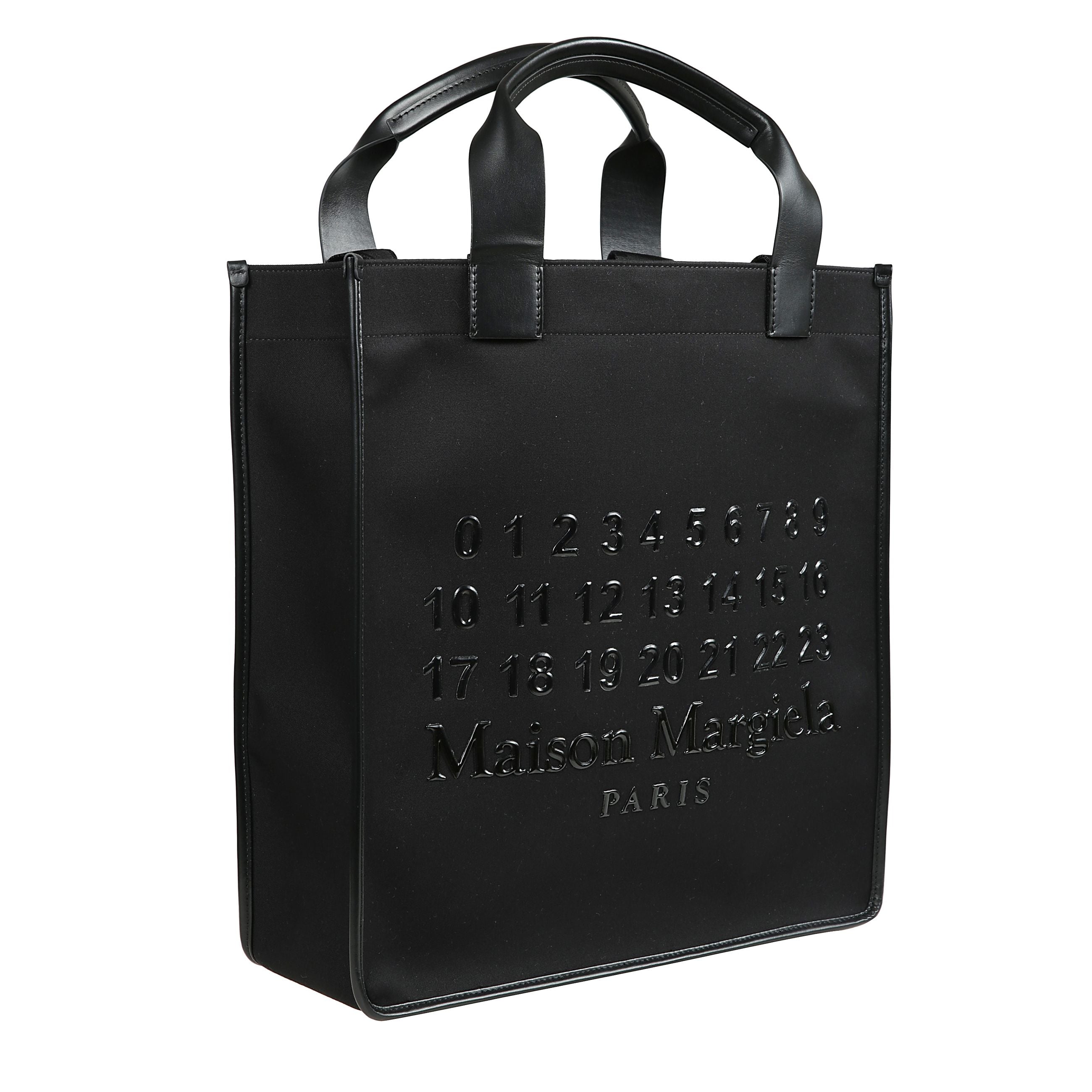 Borsa nera tote cabas in tessuto twill con chiusura magnetica nascosta e due manici tondi a tracolla rimovibile,
ha logo goffrato con numeri nella parte anteriore e scomparto unico con zip.