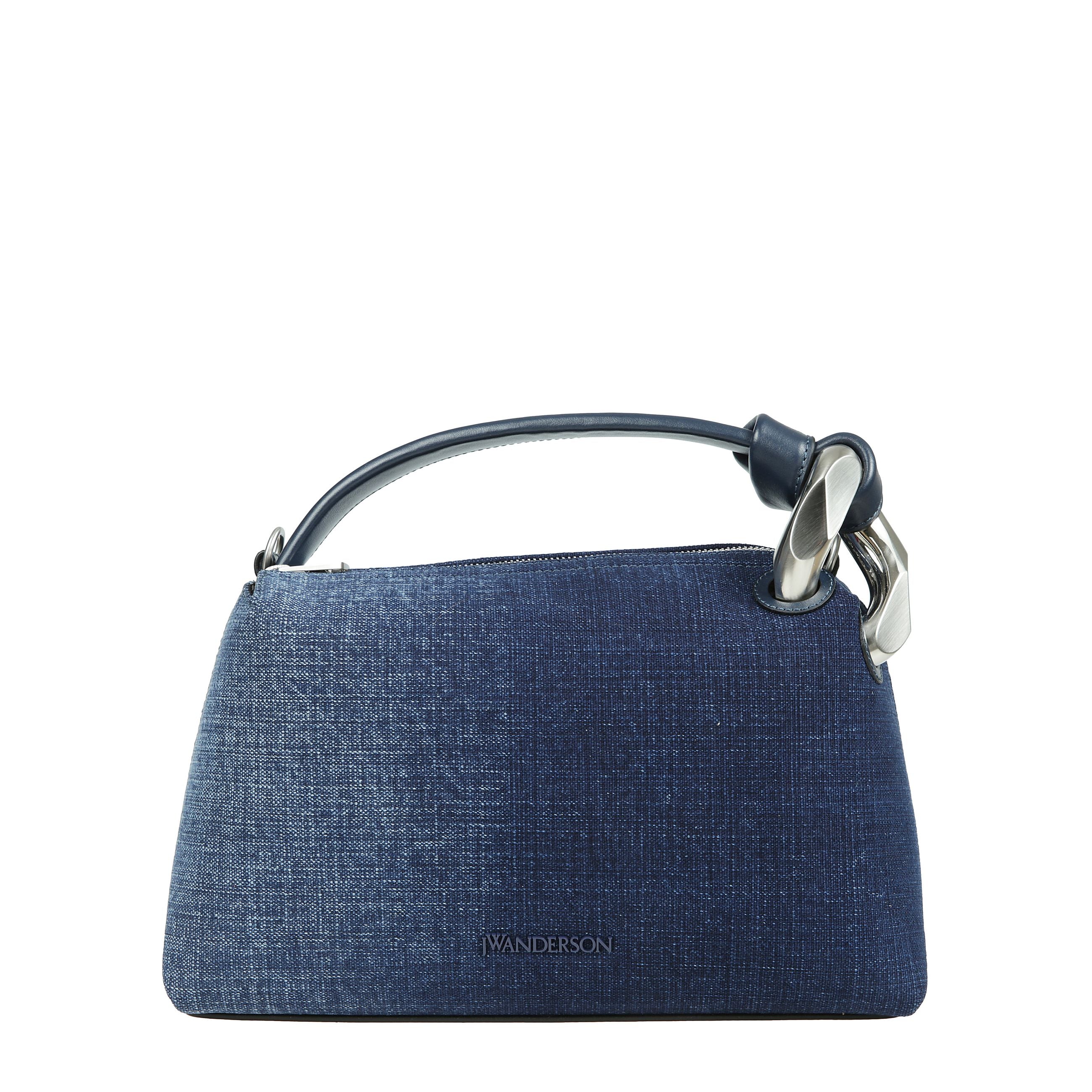 Vi presentiamo la borsa portatile della collezione esclusiva di jw anderson. questo sofisticato accessorio Ã¨ un capolavoro di design contemporaneo, caratterizzato da una forma triangolare leggermente arrotondata con eleganti linee dritte. la sua superfic