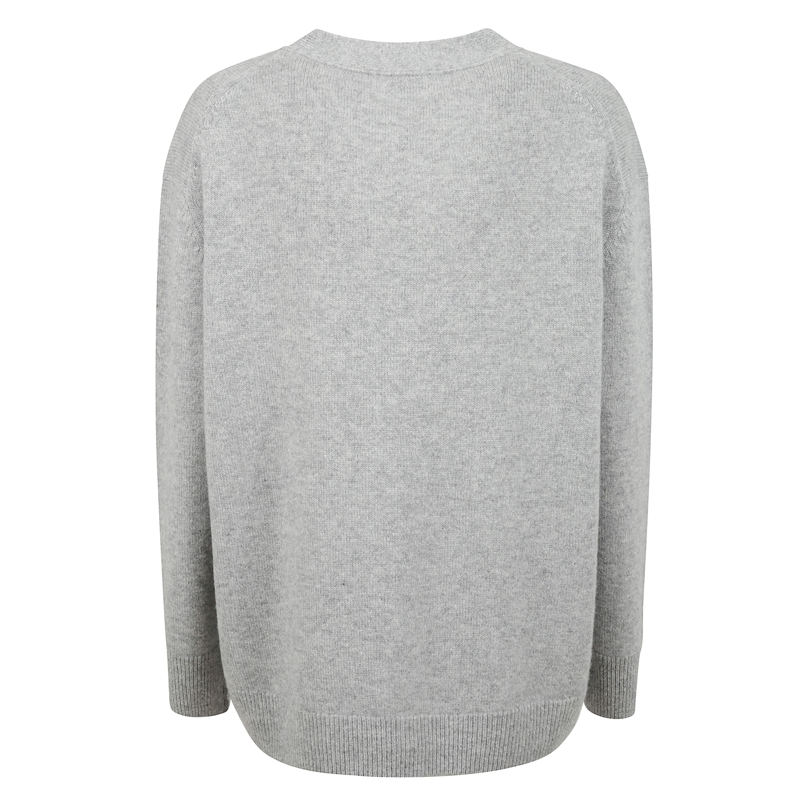 Cardigan in pregiato cashmere grigio. silhouette boxy con maniche lunghe raglan che conferisce al capo un carattere rilassato ma sofisticato. completato da chiusura frontale con bottoni e due pratiche tasche, essenziale di lusso dal design minimale e vers