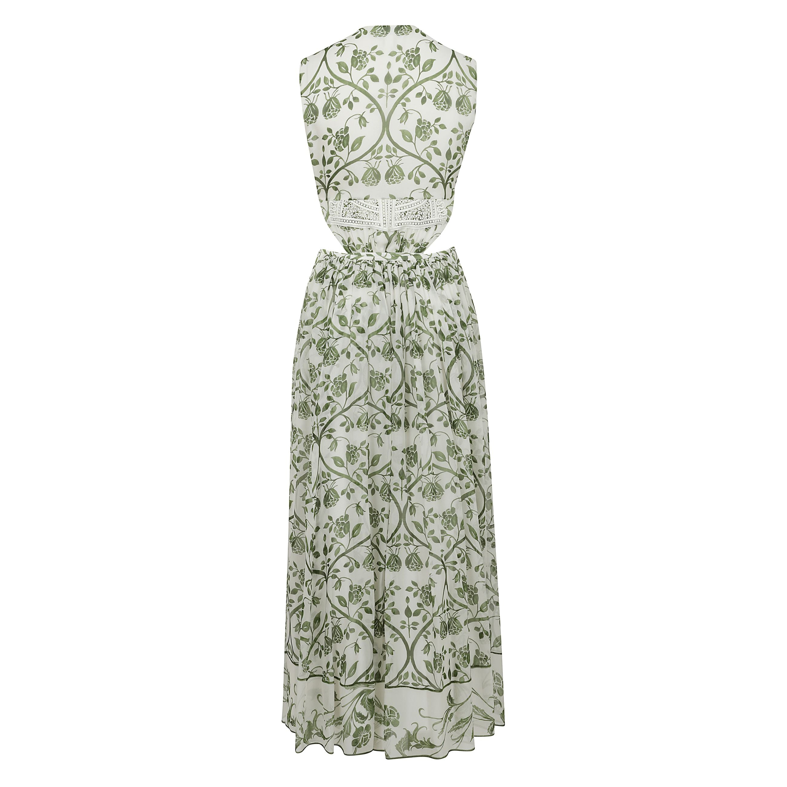 Questo abito avorio e verde con schiena nuda in georgette presenta la stampa fresco. eâ aperto sui lati ha una fodera e la cerniera laterale nascosta.