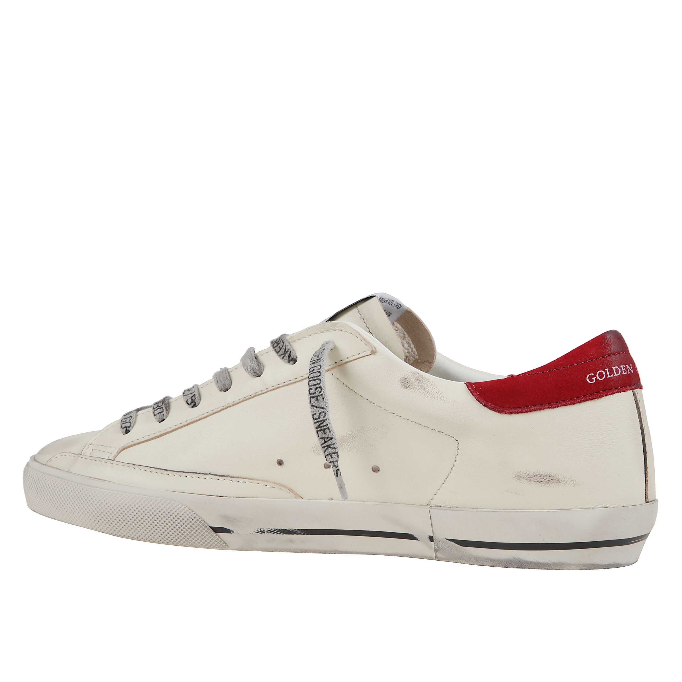 Sneakers iconiche golden goose in pelle bianca con stella in suede rosso e talloncino in pelle verde scuro. dettaglio retro in suede grigio ghiaccio e lacci grigi. effetto vintage. tomaia in pelle bovina, suola in gomma. fatte a mano in italia.