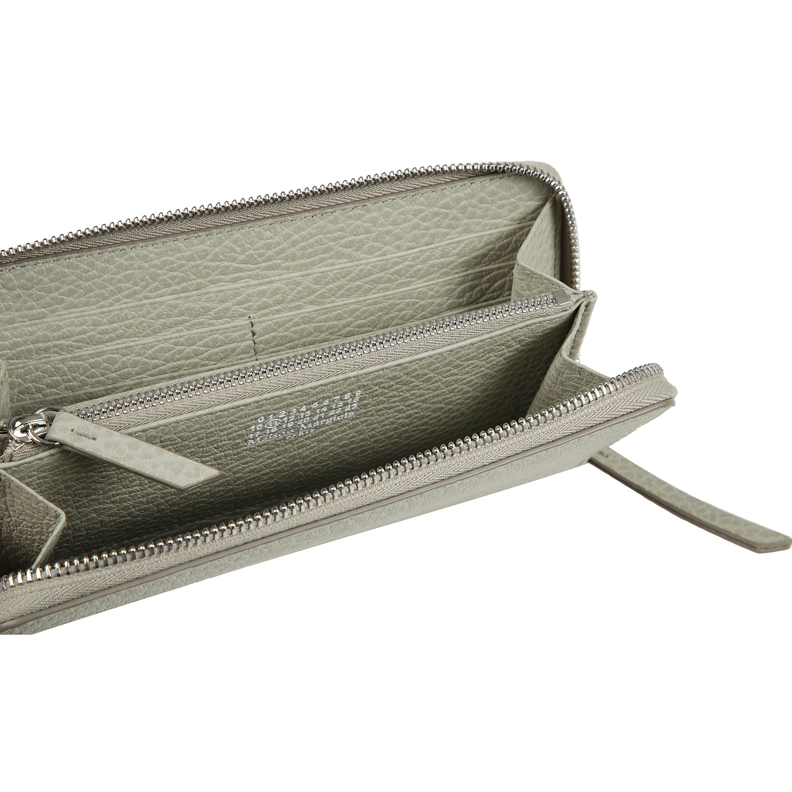 Realizzato in pelle sgranata goffrata, il portafoglio con cerniera ha un portamonete interno con zip e porta carte, con logo numerico interno. la firma di maison margiela, i quattro punti, appaiono sul retro  l'opposto di un'etichetta.
