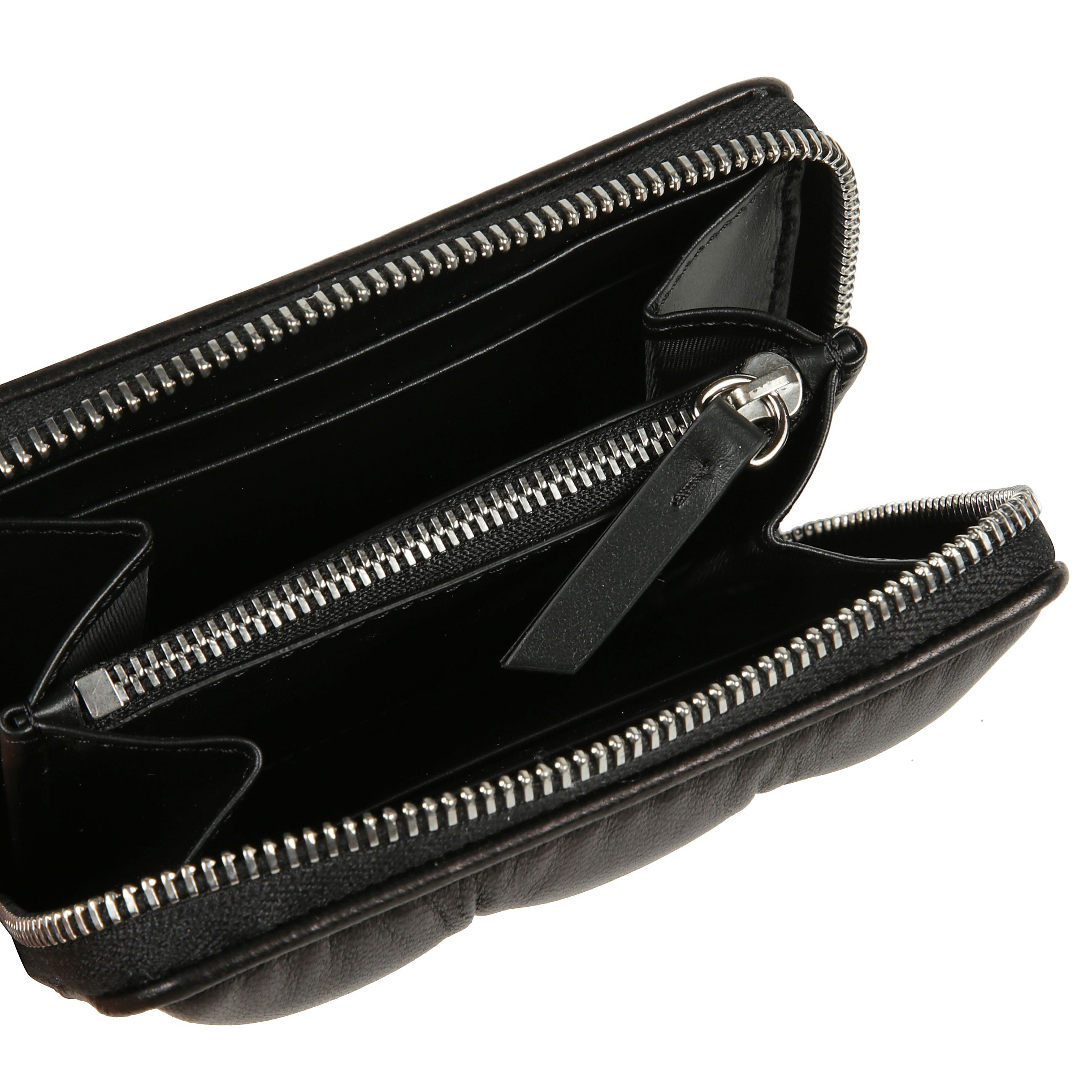 Portafoglio bi-fold in pelle con chiusura zip. imbottitura trapuntata. interno organizzato con vari scomparti e tasca con zip portamonete. etichetta metallica con logo numerico maison margiela sul fronte.