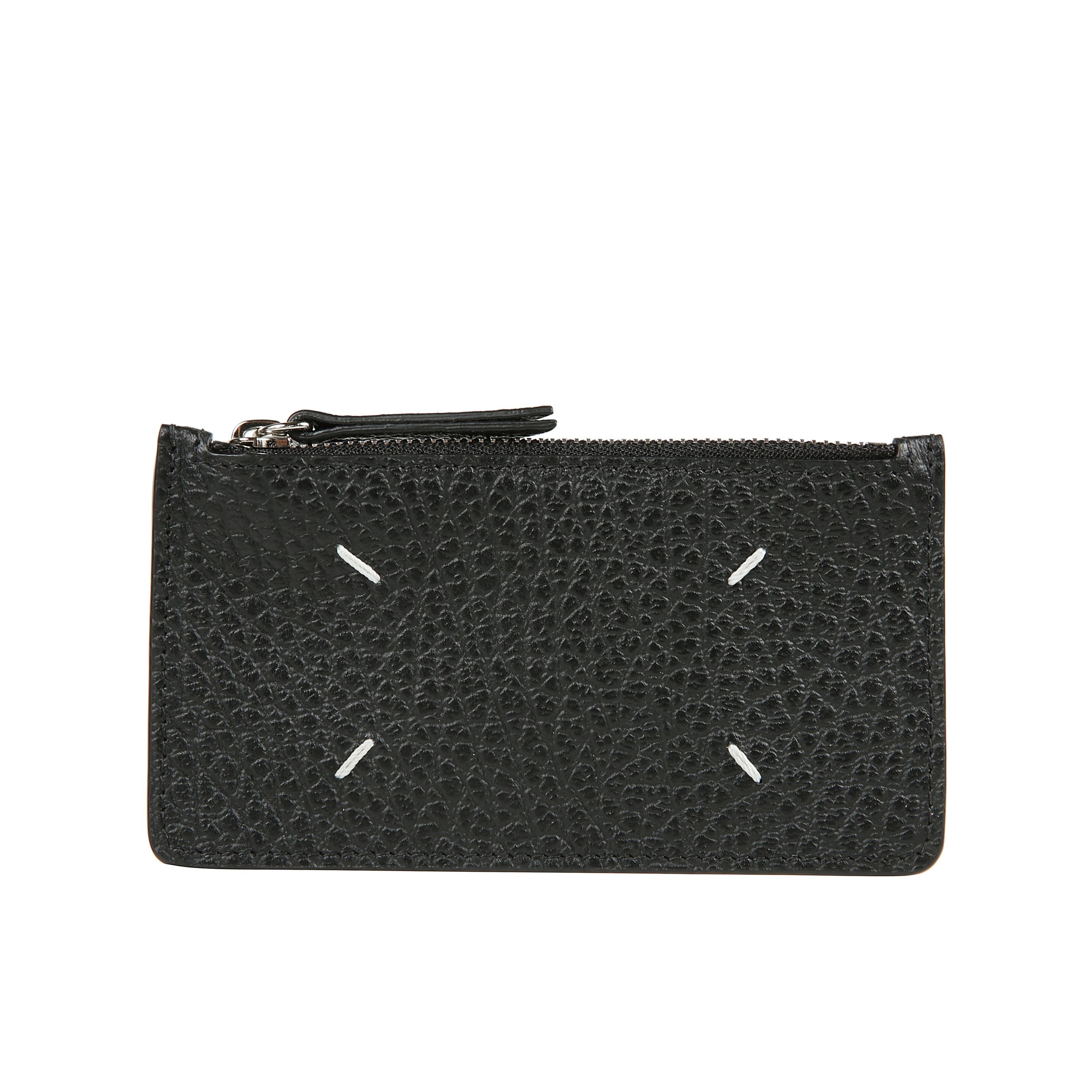 Portafoglio-portacarte in pelle martellata, con tasca a zip per le monete e cinque scomparti portatessere. numeric logo visibile allâinterno. sul retro, spiccano four stitches, caratteristica indiscussa di maison margiela : lâopposto di unâetichetta