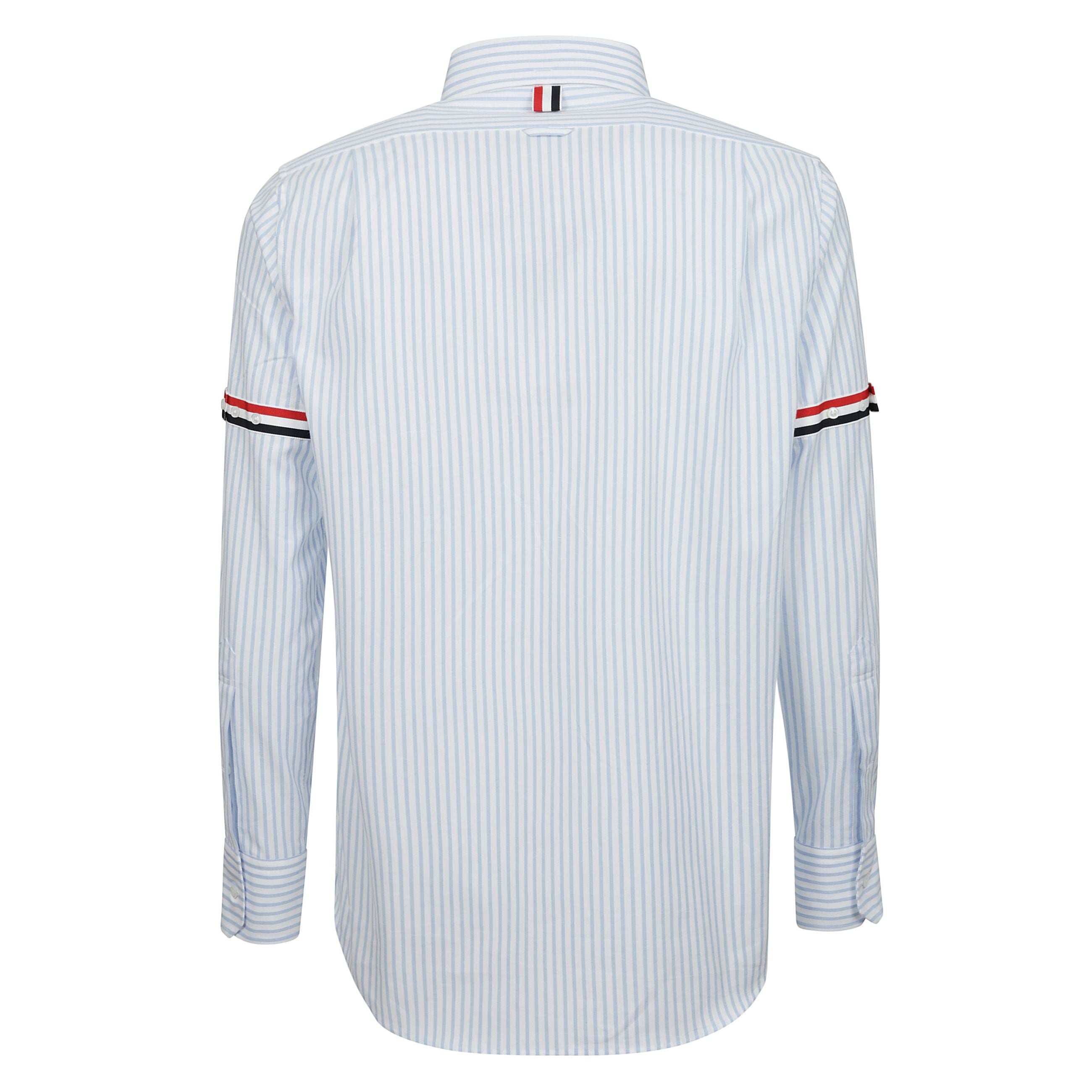 Camicia in cotone a righe caratterizzata da colletto button-down, manica lunga con polsi con bottoni e dettaglio tricolore a contrasto, abbottonatura frontale, una tasca applicata sul petto, dettaglio tricolore posteriore, patch logo sul davanti e orlo cu