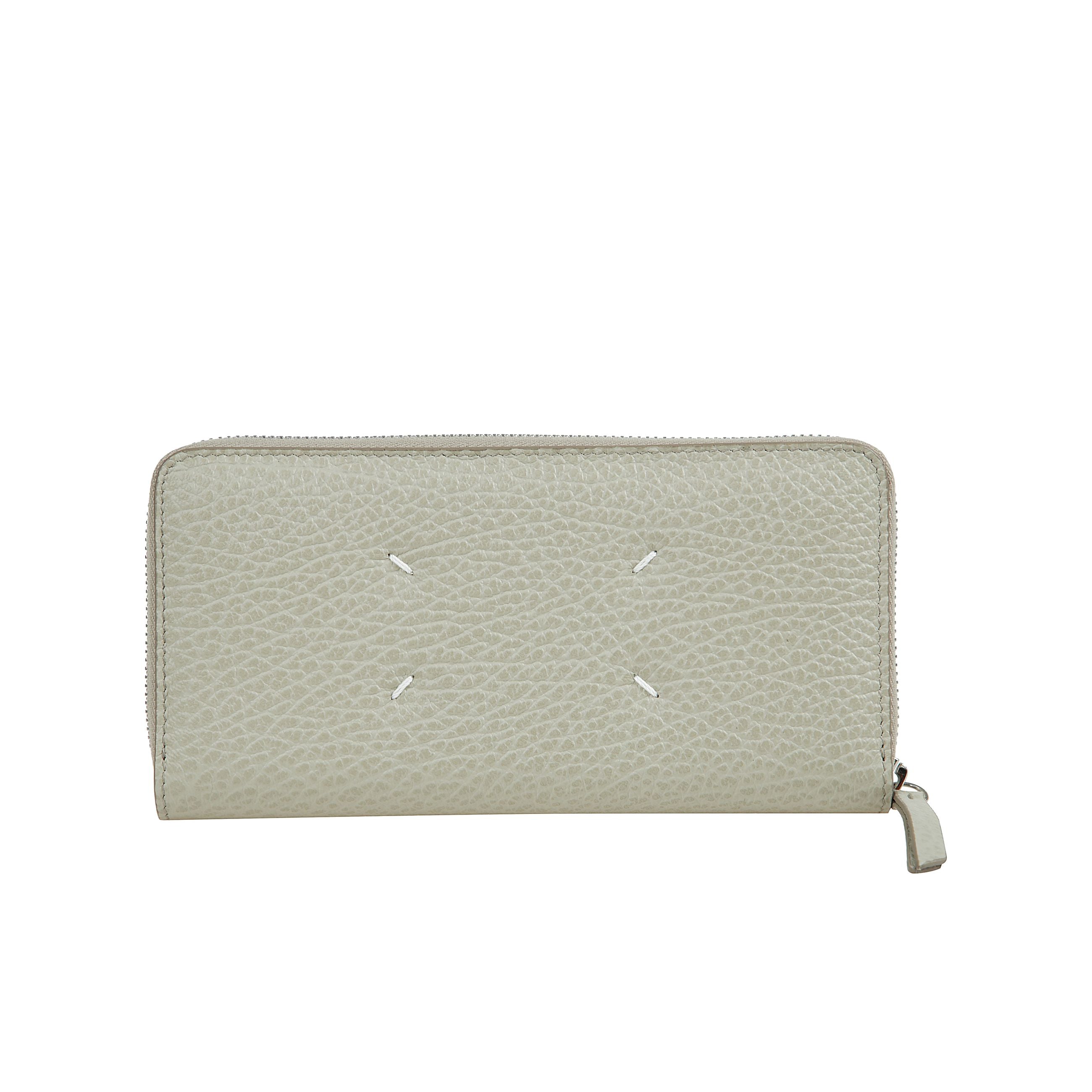 Realizzato in pelle sgranata goffrata, il portafoglio con cerniera ha un portamonete interno con zip e porta carte, con logo numerico interno. la firma di maison margiela, i quattro punti, appaiono sul retro  l'opposto di un'etichetta.