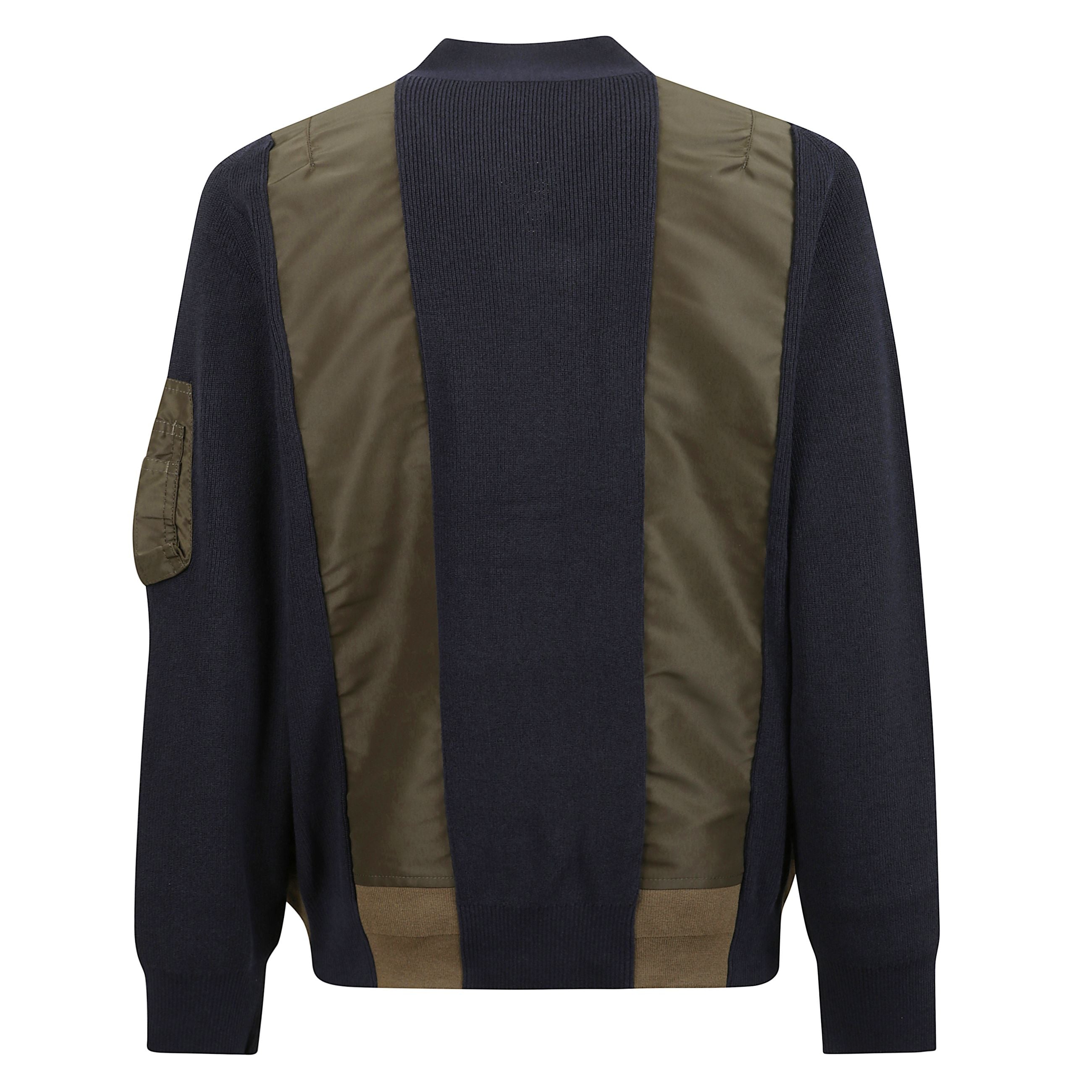 Giacca con tessuto a costine verticali ed inserti in tessuto tecnico lucido.  chiusura frontale con zip in posizione asimmetrica. orli e polsini a costine. grande tasca frontale stile marsupio, due tasche frontali a filetto e una tasca sulla manica con ch