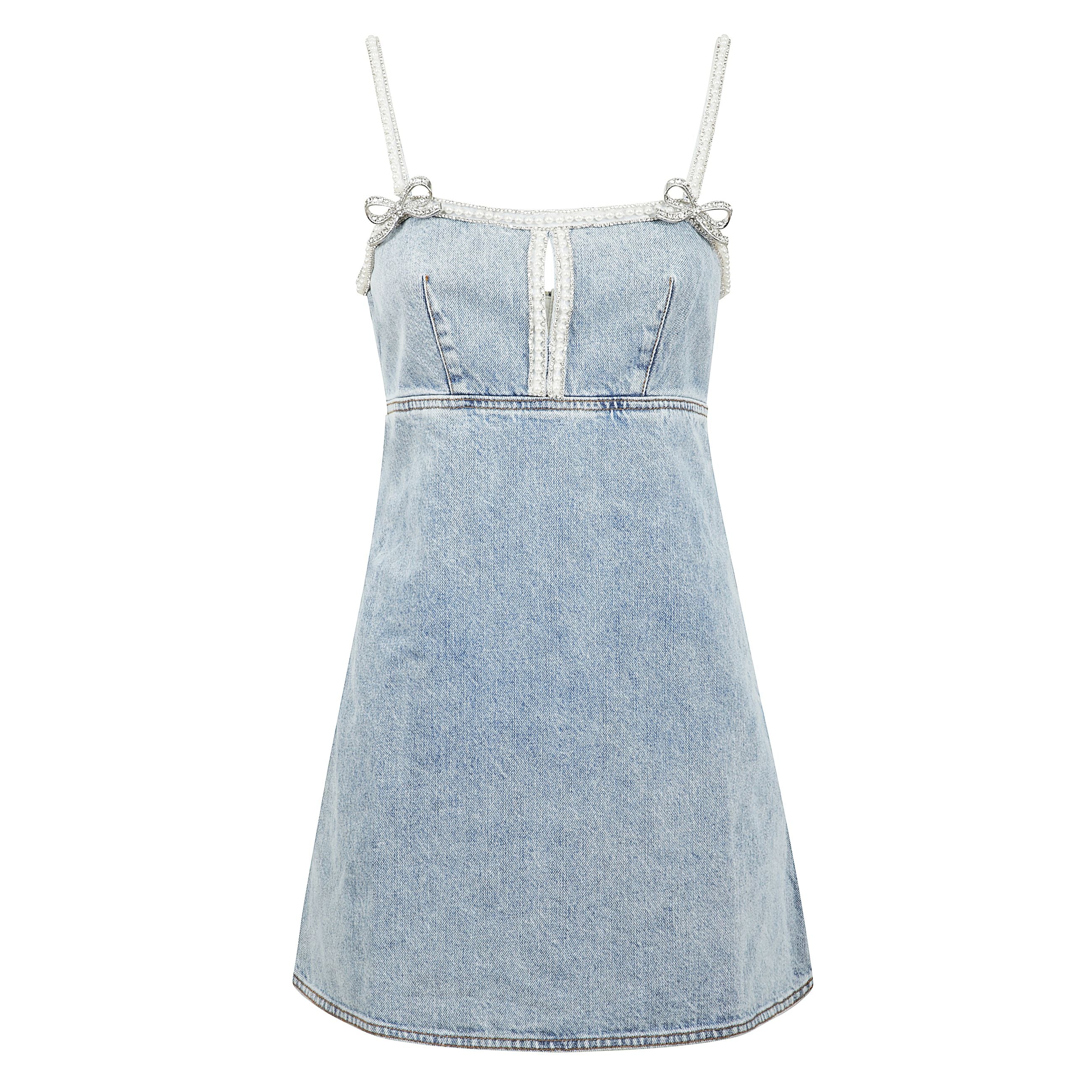 Mini abito dal design in denim , spalline impreziosite da micro strass, scollatura a goccia sul davanti e  due fiocchi iconici  decorativi scintillanti a contrasto