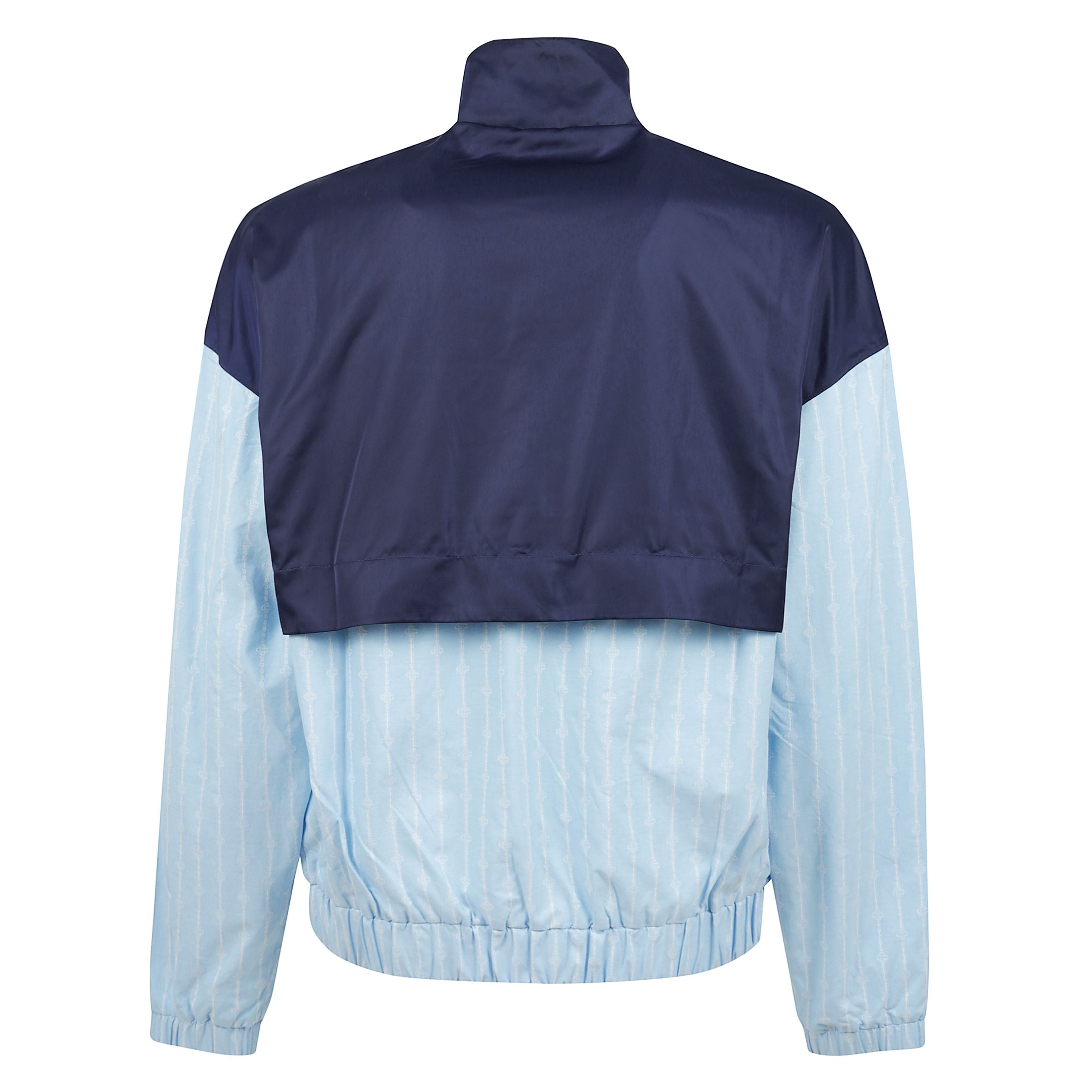 Giacca di colore blu con chiusura frontale a zip, due tasche a filetto laterali, orli elasticizzati e orlo elasticizzato.