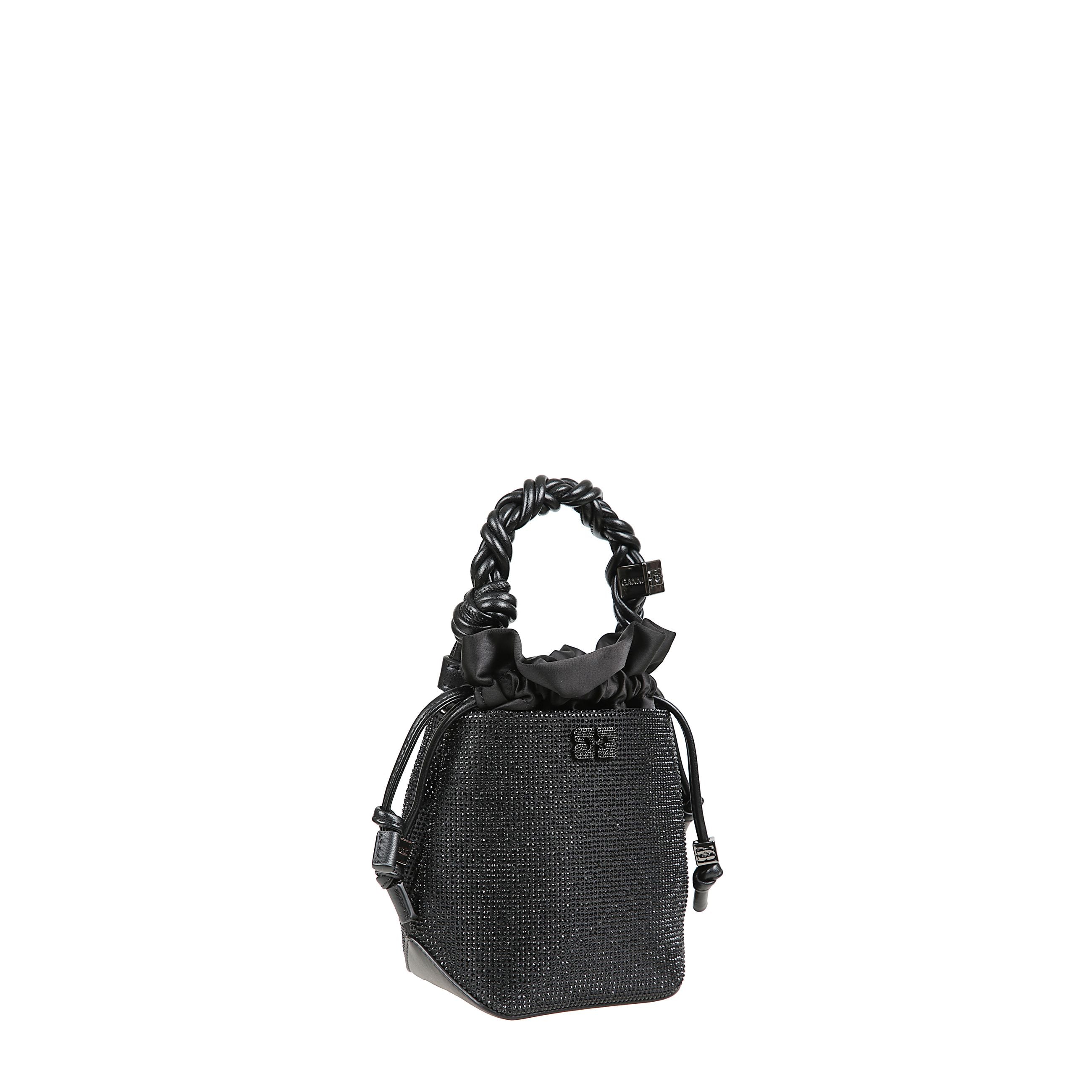 Ganni bou bucket mini decorata con strass tono su tono, presenta un manico superiore intrecciato con nodo intrecciato, un dado metallico con il logo ganni e la farfalla incisi e una catena rimovibile color argento con i loghi metallici ganni butterfly. la