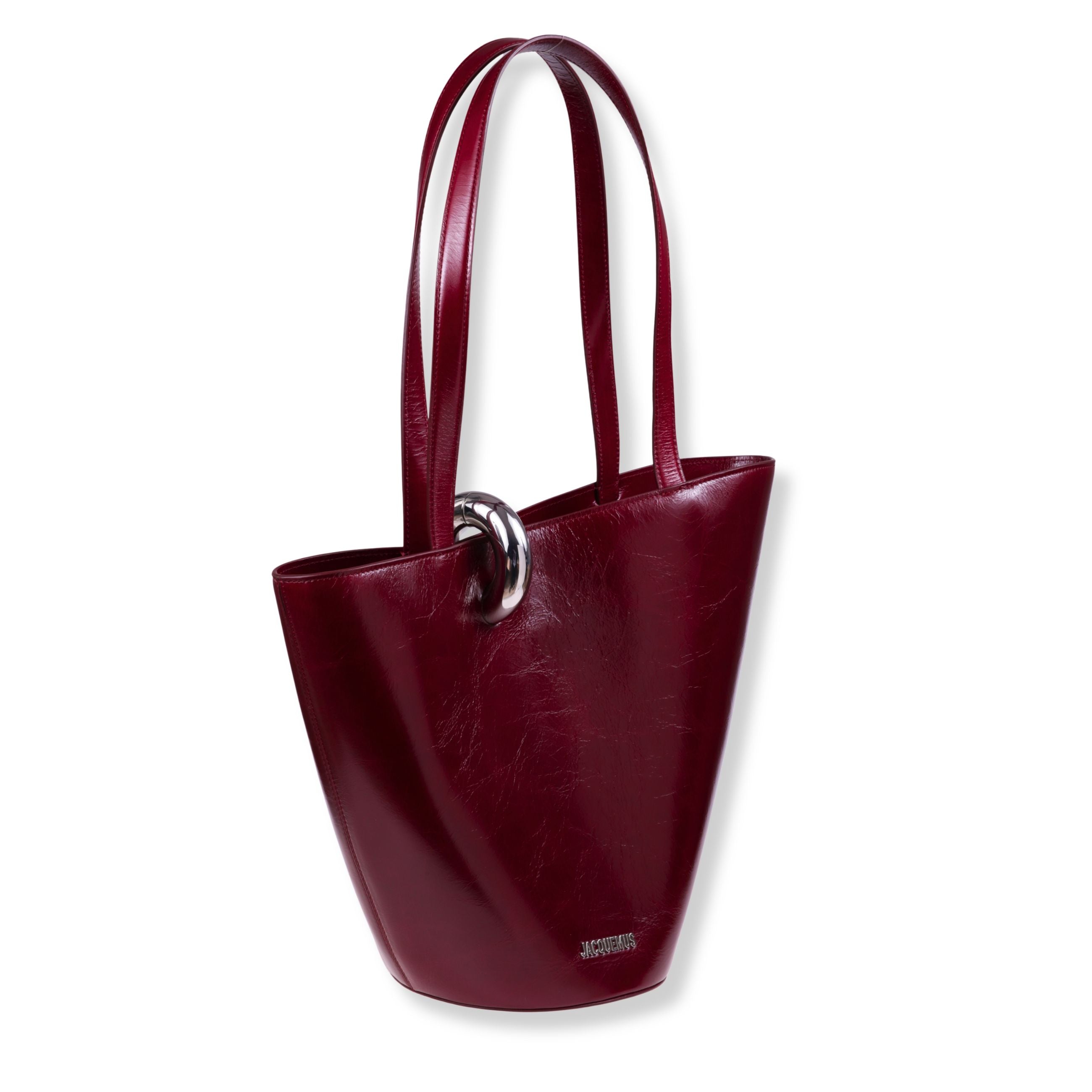 Le bambola moyen jacquemus. design in pelle effetto lucido con forma asimmetrica a secchiello. doppi manici superiori. chiusura superiore con un anello in metallo argentato.