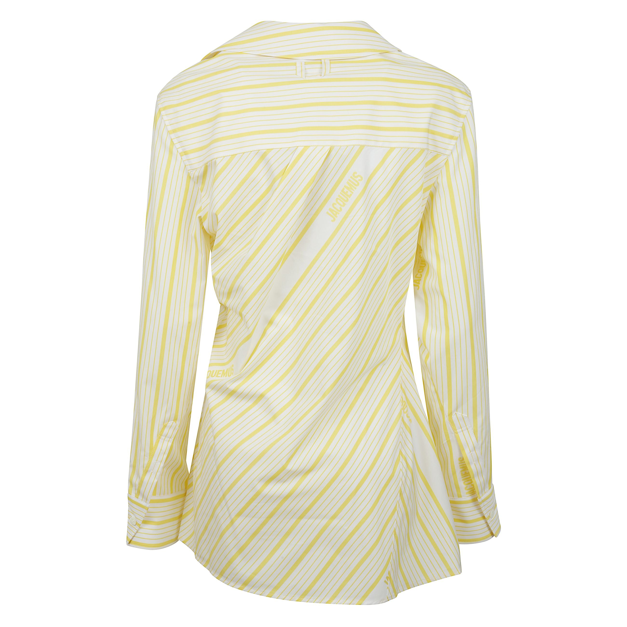 La camicia di jacquemus a righe senza schienale con taglio aderente in cotone e colletto a punta. tasca asimmetrica a "j" sul petto.