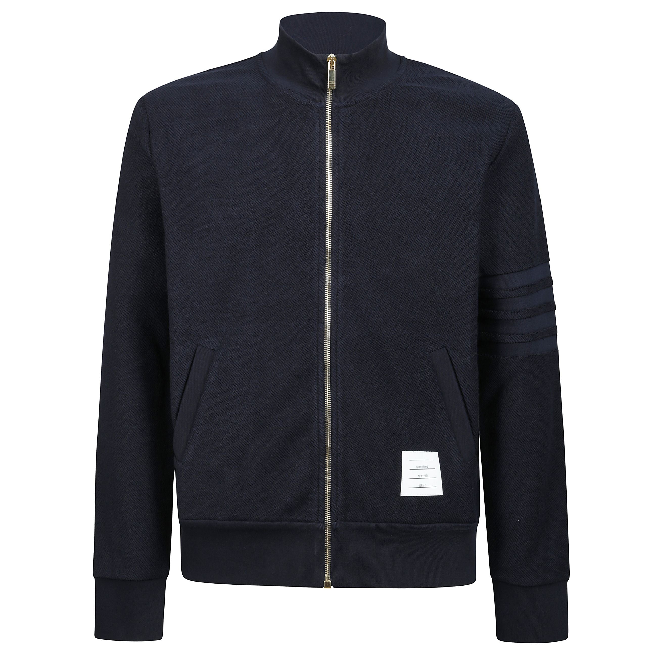 La lavorazione impeccabile, il cotone pregiato e i distintivi emblemi di thom browne rendono questa giacca versatile essenziale per il tuo guardaroba primaverile. con chiusura frontale a zip e 2 tasche anteriori a slittamento.