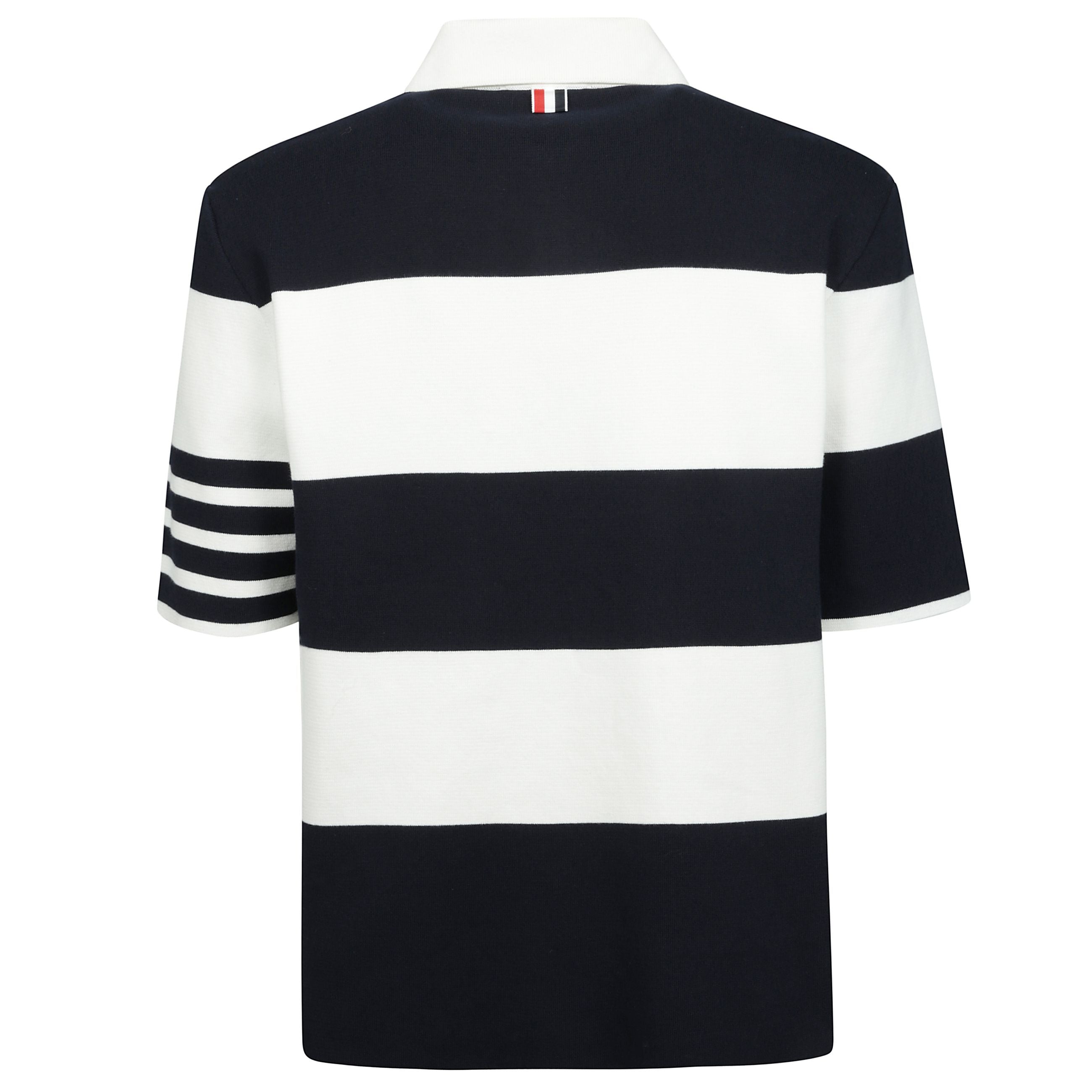 La maglia polo milano in cotone di thom browne Ã¨ un capo dallo stile elegante e distintivo. presenta un colletto classico e una chiusura frontale con bottoncini, mentre gli spacchi laterali aggiungono un tocco di dinamismo al design. la fantasia a righe 