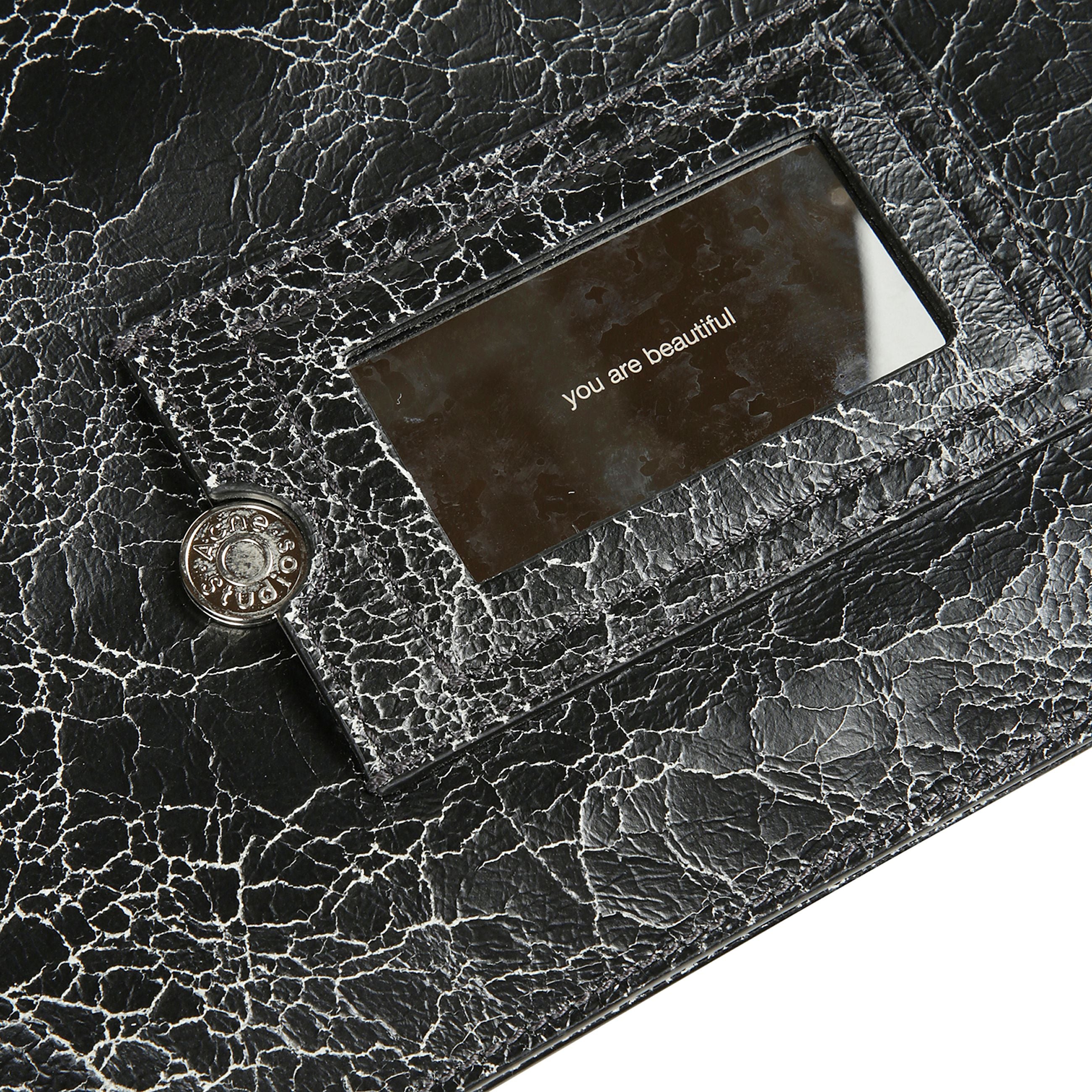 La borsa a tracolla platt ha una silhouette minimalista piatta, un top leggermente curvo con pieghe strutturate a fisarmonica sul lato e sulla base. in pelle con effetto screpolato. patch con logo acne studios in pelle sul davanti e specchio decorativo ri