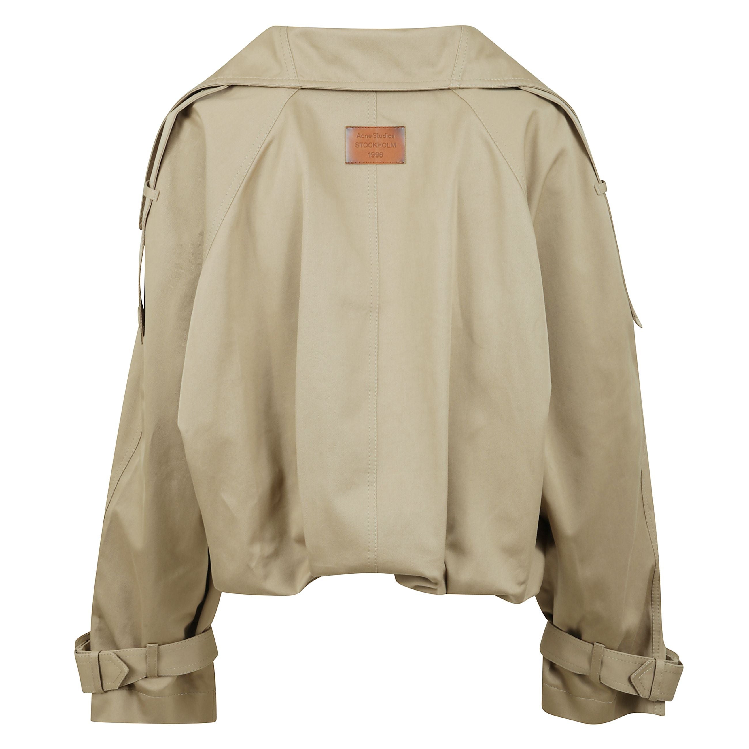 Trench con lunghezza sotto la vita e vestibilitÃ  ampia. collo allungato e fondo plissettato. chiusura frontale con bottoni e tasche frontali e interne. pattine stile trench sulle spalle. cinture regolabili ai polsi. patch con logo acne studios stockholm 