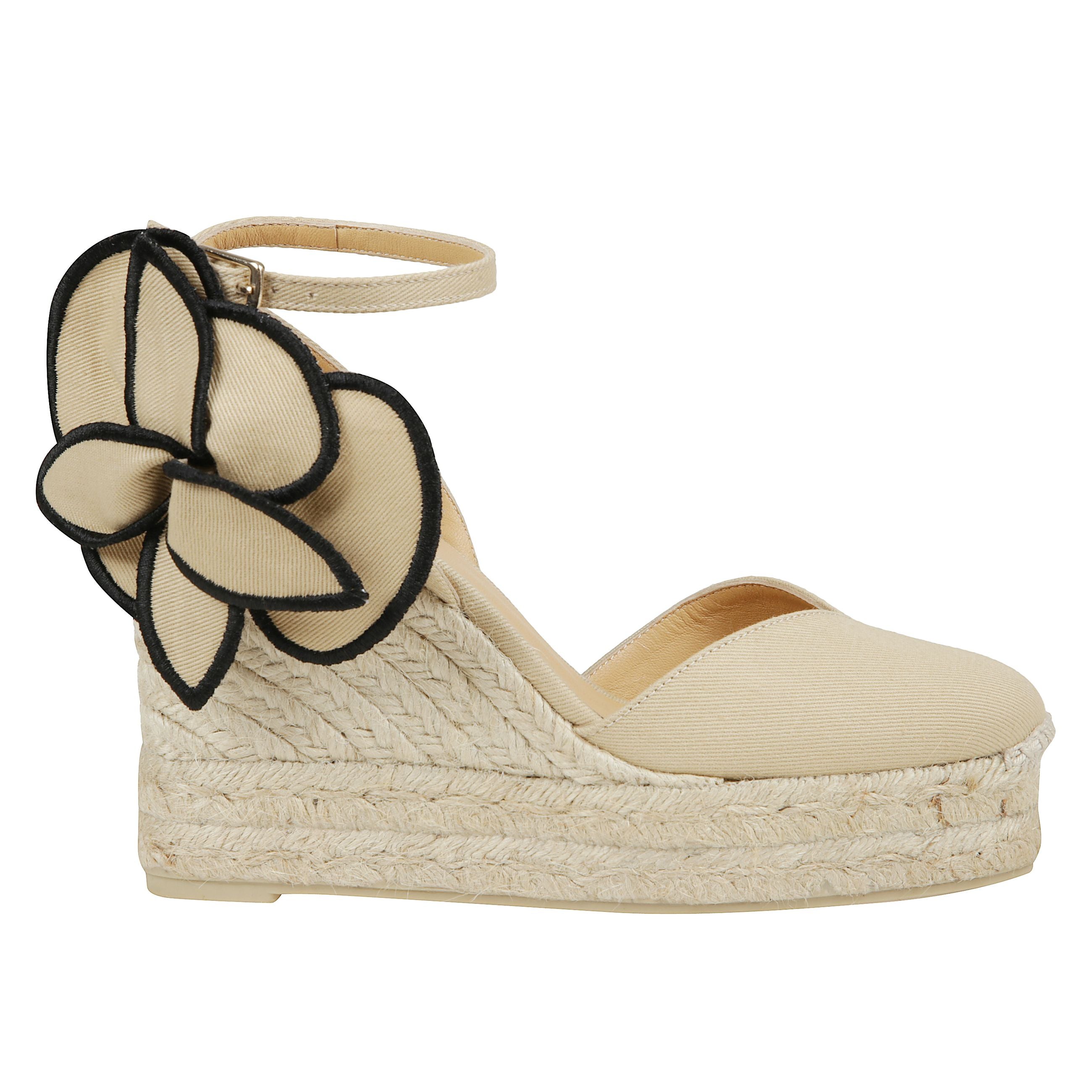 Espadrillas alta caratterizzata da tomaia in cotone, soletta con stampa logo, punta tonda, chiusura alla caviglia con lacci, dettaglio fiore laterale e tacco a zeppa in raffia.